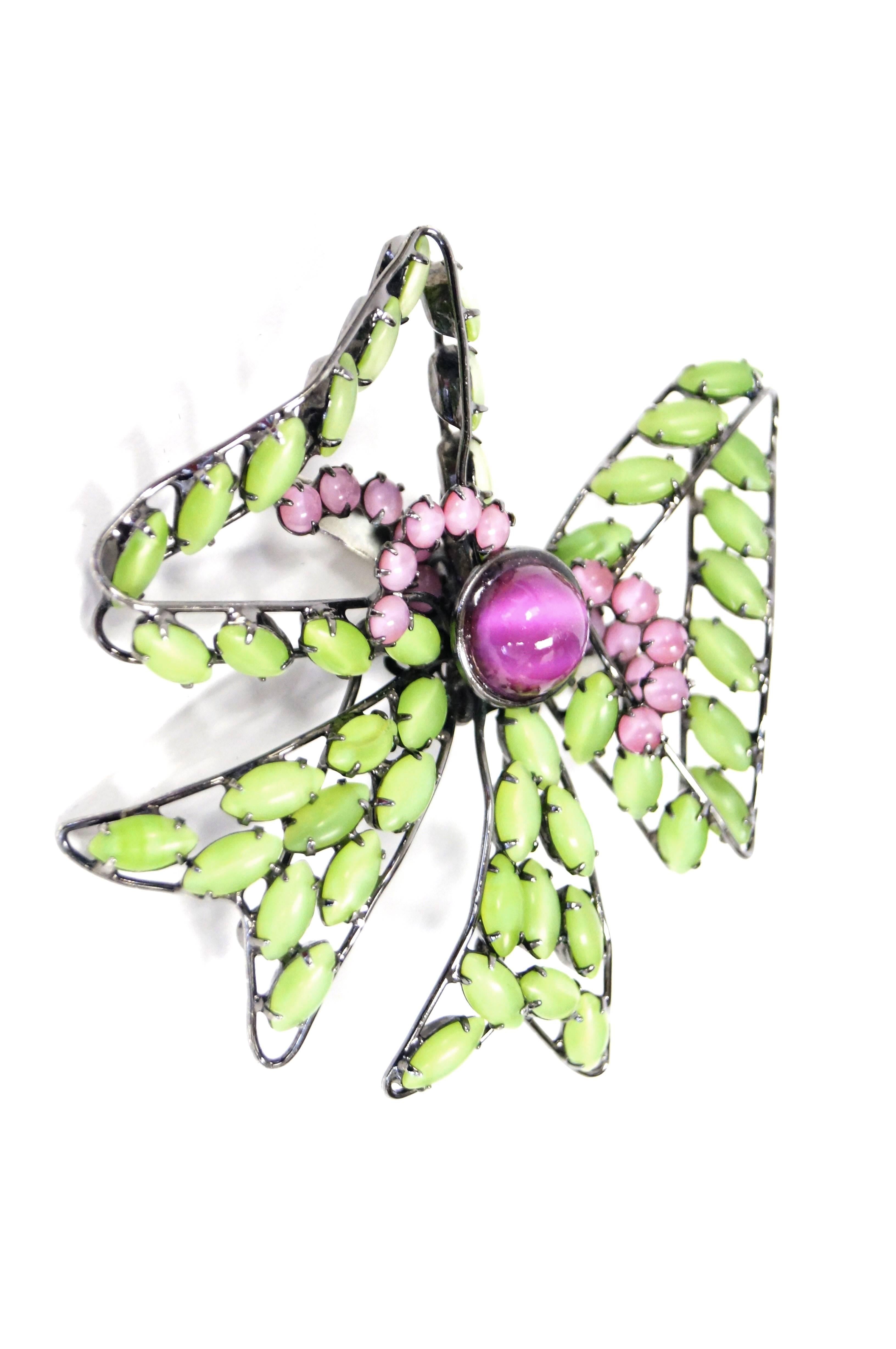 Playful spring green and blossom pink bow brooch by Lawrence Vrba. The bow is composed of frosted green oval marquise cabochons, with a bright pink, round cat-eye cabochon center. The center of the bow is ornamented with two springs of round pink