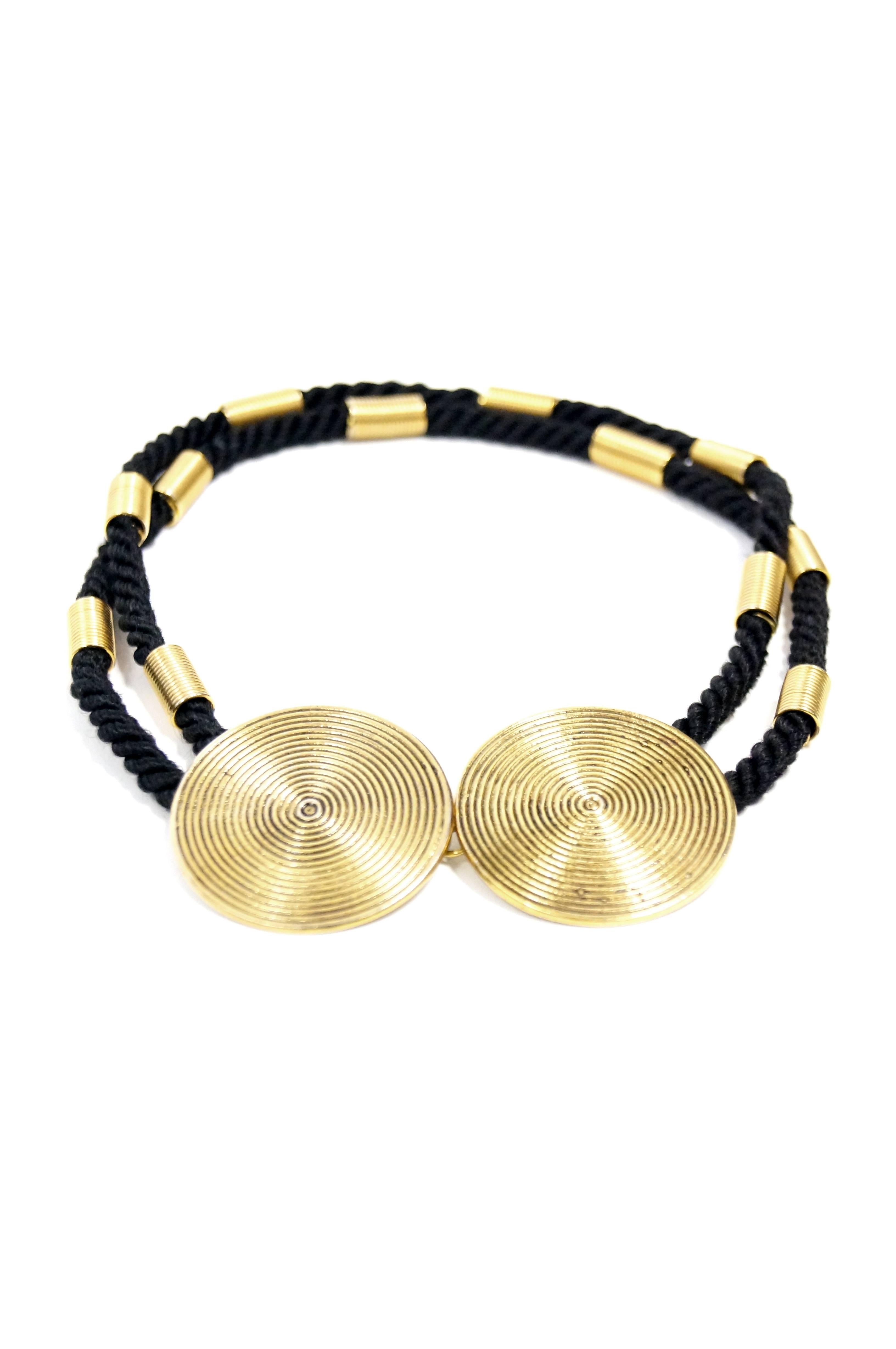 Wonderful modernist necklace by Yves Saint Laurent. This choker necklace is composed of twirl braided silk ropes, each decorated with six long spring - like tube beads. The necklace features two large disks marked with concentric circles. The discs