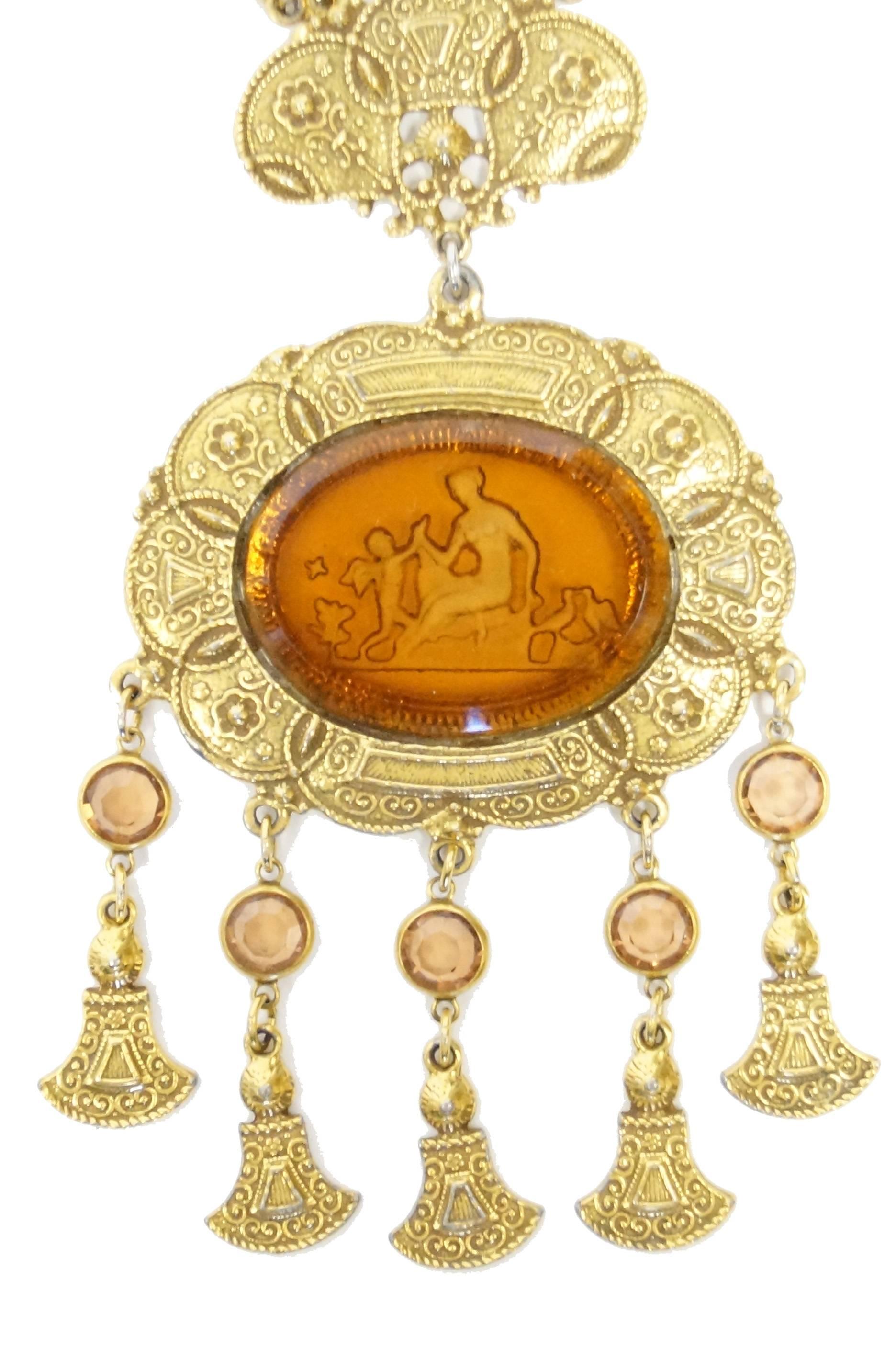 Amazing oversized amber - tone intaglio medallion necklace! The gold - tone necklace features a horizontal oval intaglio depicting Cupid and Psyche. Cupid is in his popular cherubic form, while Psyche is as she appears in Apuleius's 