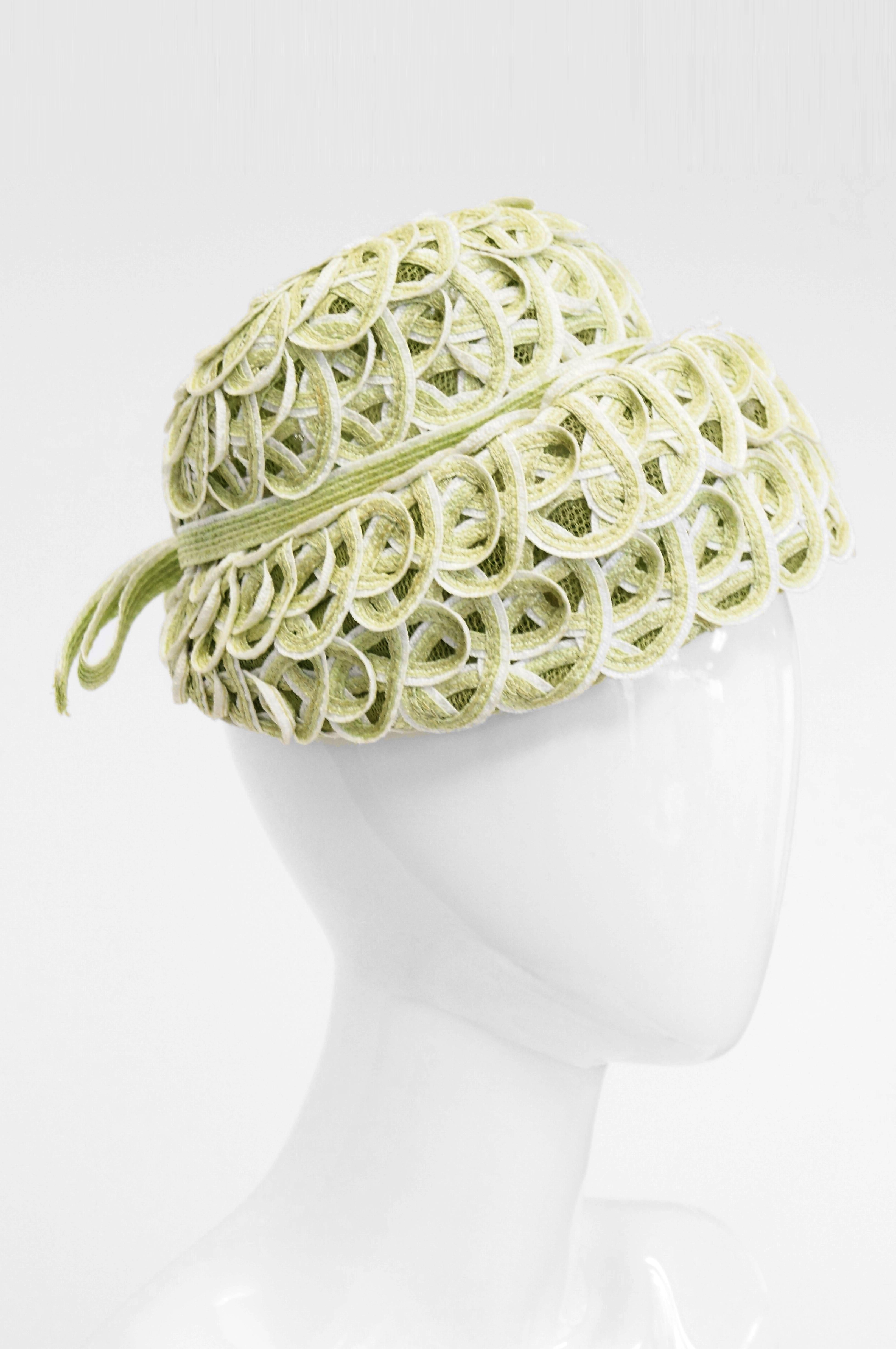 Striking and flirty comes this adorable green woven hat by Balenciaga! This bonnet - like hat is composed of ovarlapping white and green loops, and features a low, round crown, and a brim that curves downwards towards the wearer's face. The