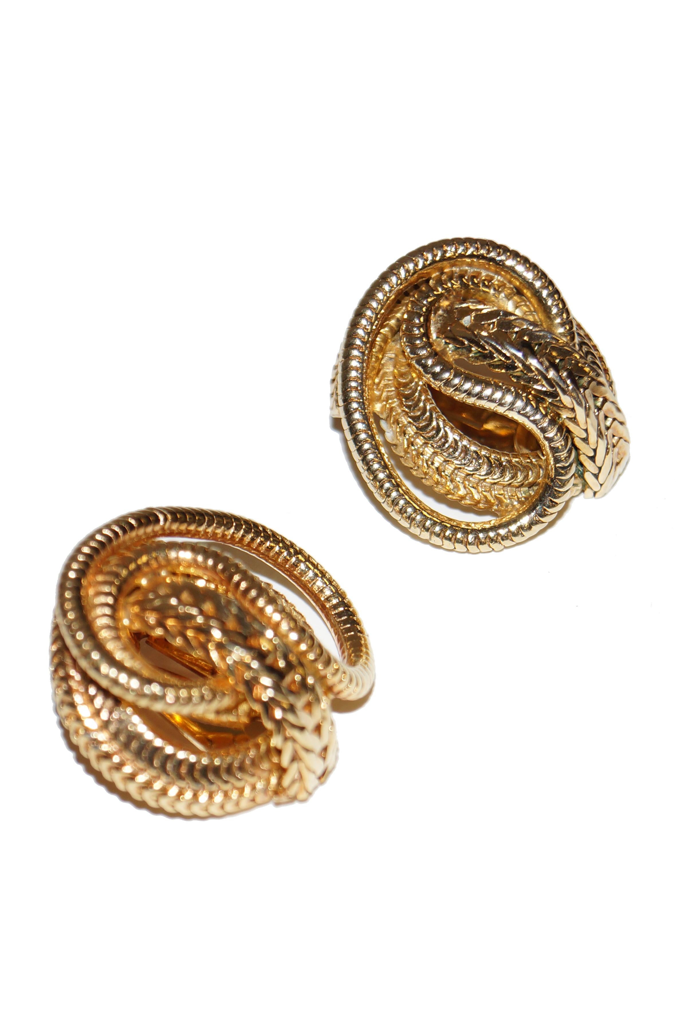 Stunning scintillating gold snake chain earrings by Hattie Carnegie! The earrings feature free swirling gold tone snake chains wrapping underneath a larger chain with chevron - like marks. Simple but stunning! 

Hattie Carnegie was born Henrietta