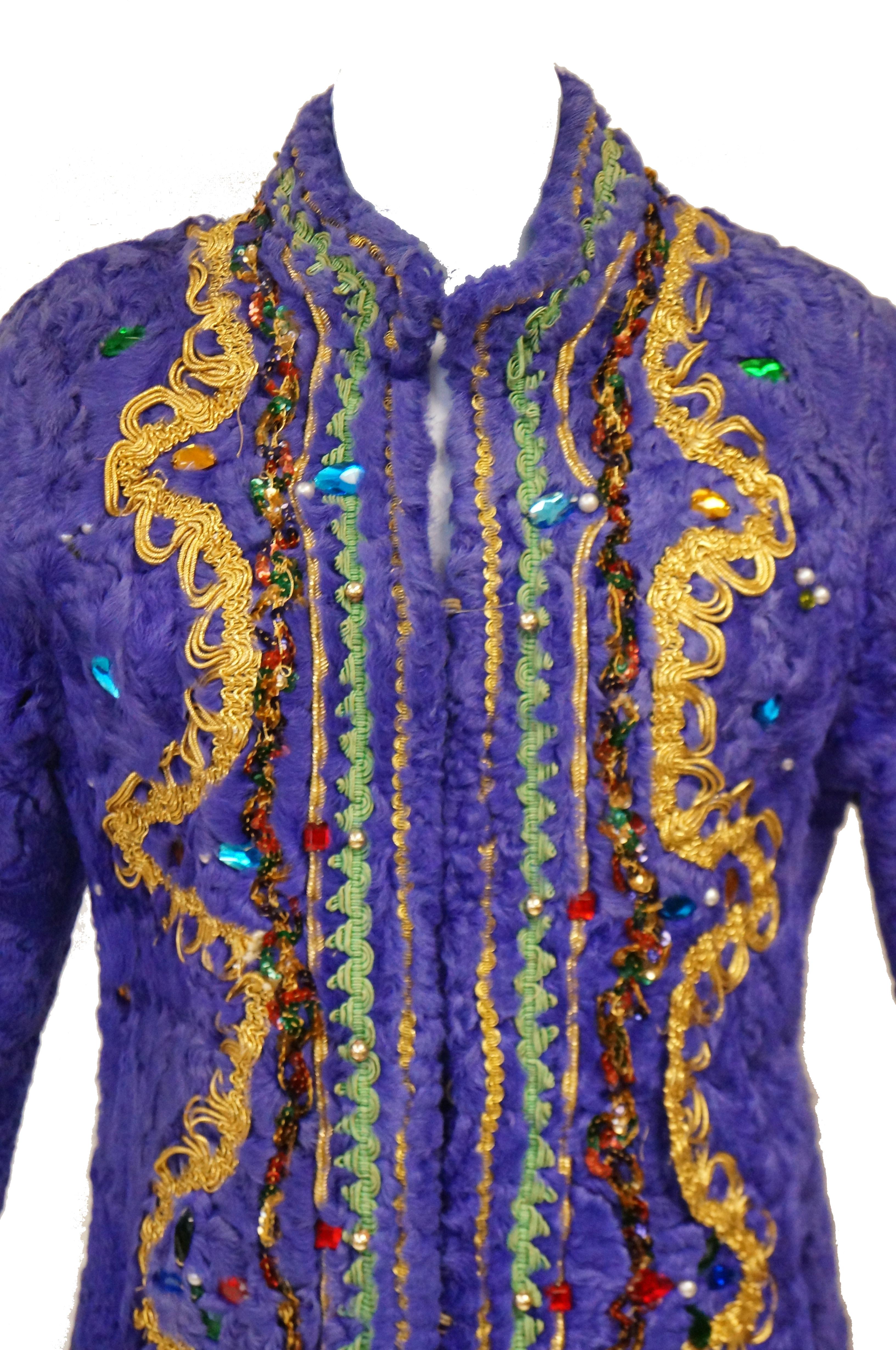 Have you ever seen such an outrageous coat?! This purple - dyed Persian lamb coat is full length, with a mandarin collar, and long sleeves. The coat is ornamented with gold and pistachio green passementerie, coils of red, orange, and green sequins,