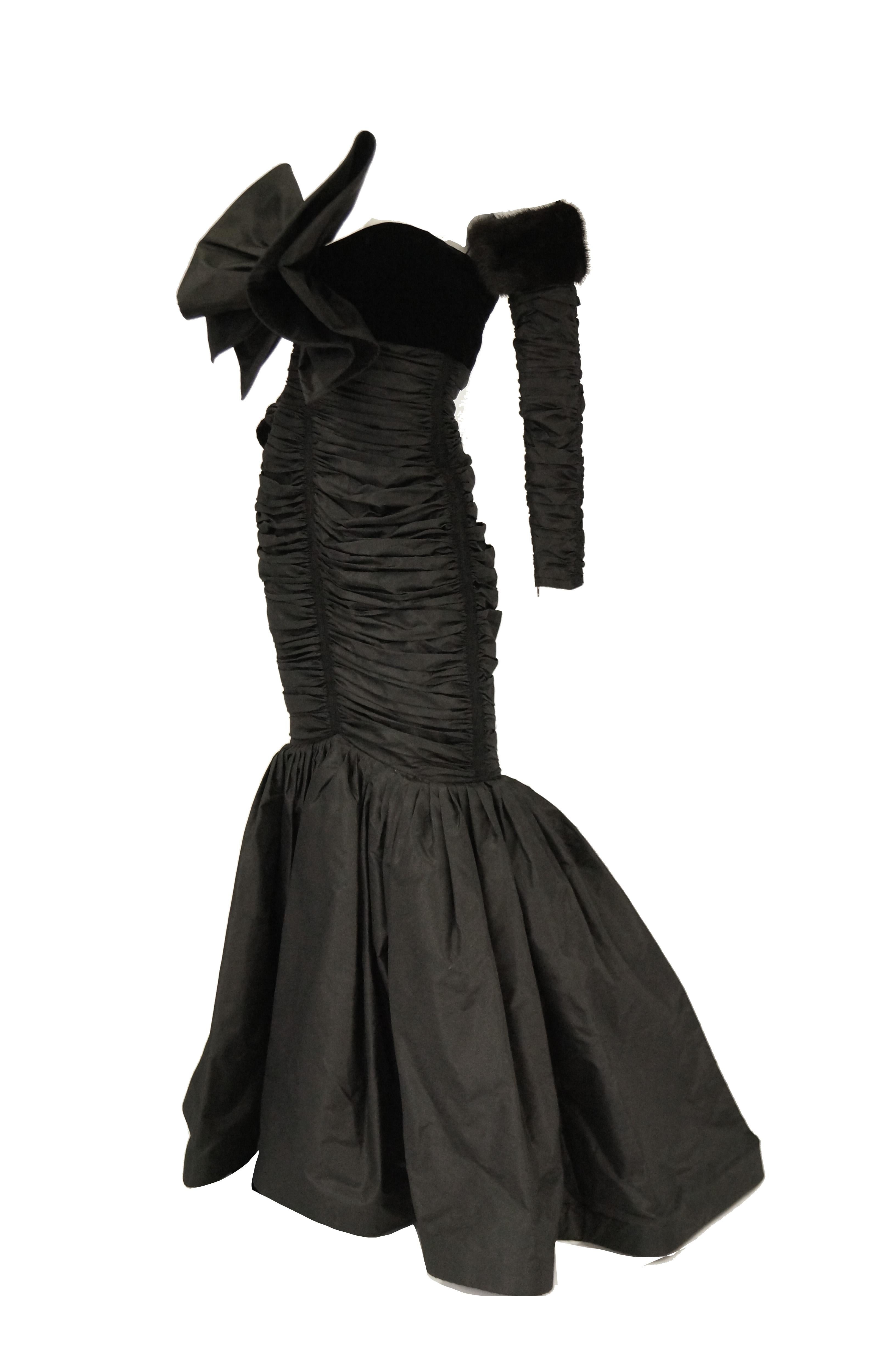 Amazing fit and flair evening gown by Nina Ricci. The black dress is maxi length with a strapless bodice, and curve - hugging silhouette with ruching detail that runs from just below the velvet bust down to the knee. The front of the dress features