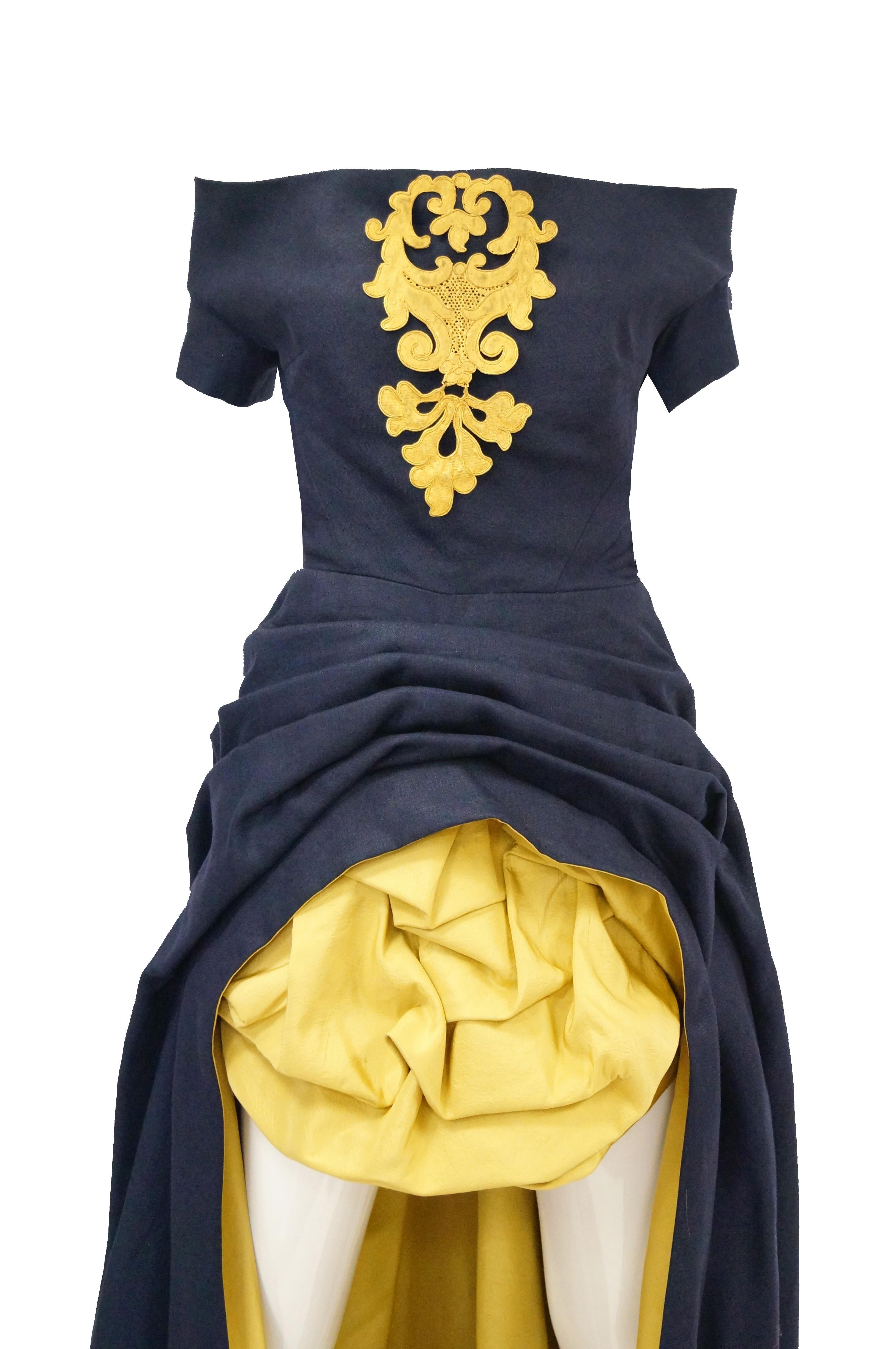 Museum worthy and quite wearable 1991 Couture Navy and Gold gown. Dress contains inner corset with boning and zipper and an inner belt. Detachable large gilt gold breast brooch based on 17th Century strapwork design. Gathered at hips and under mini