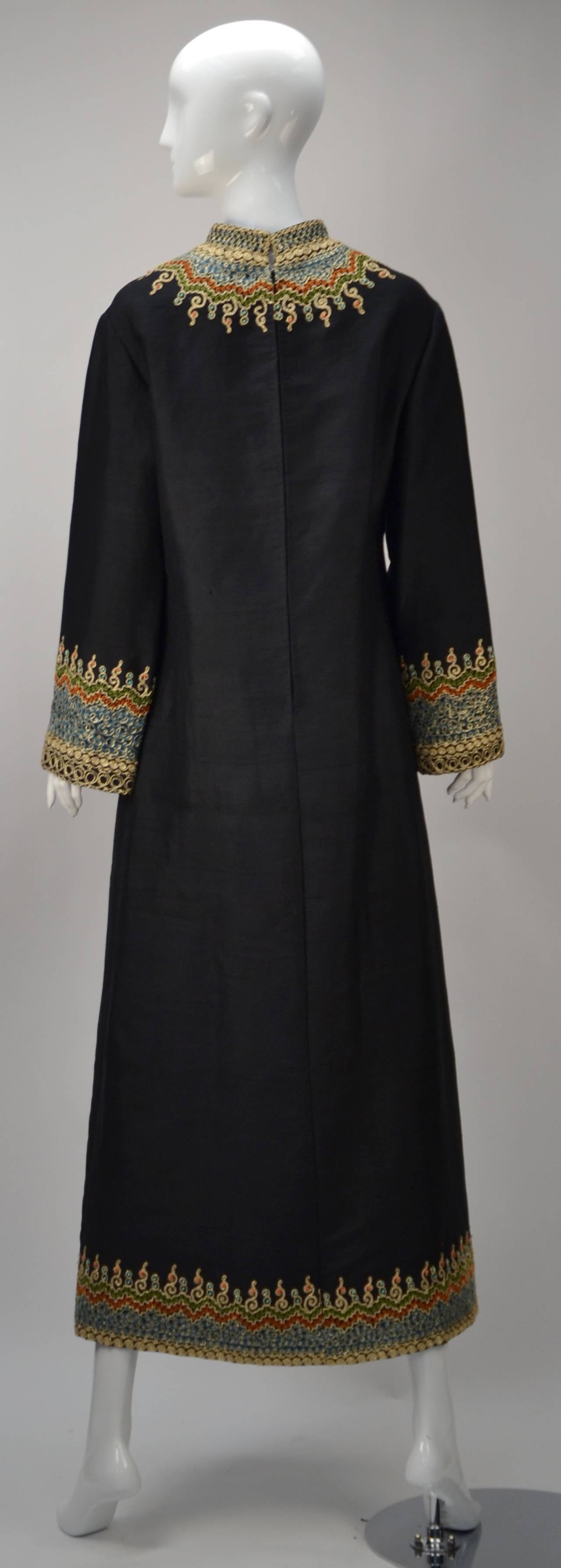Stunning black silk caftan extravagantly embroidered with metallic gold, green, orange and blue threads. Coral and turquoise beading. Traditional V-neck with mandarin collar. Center front slit. Exquisite!

Modern US size 6/8.

Slit measurement: