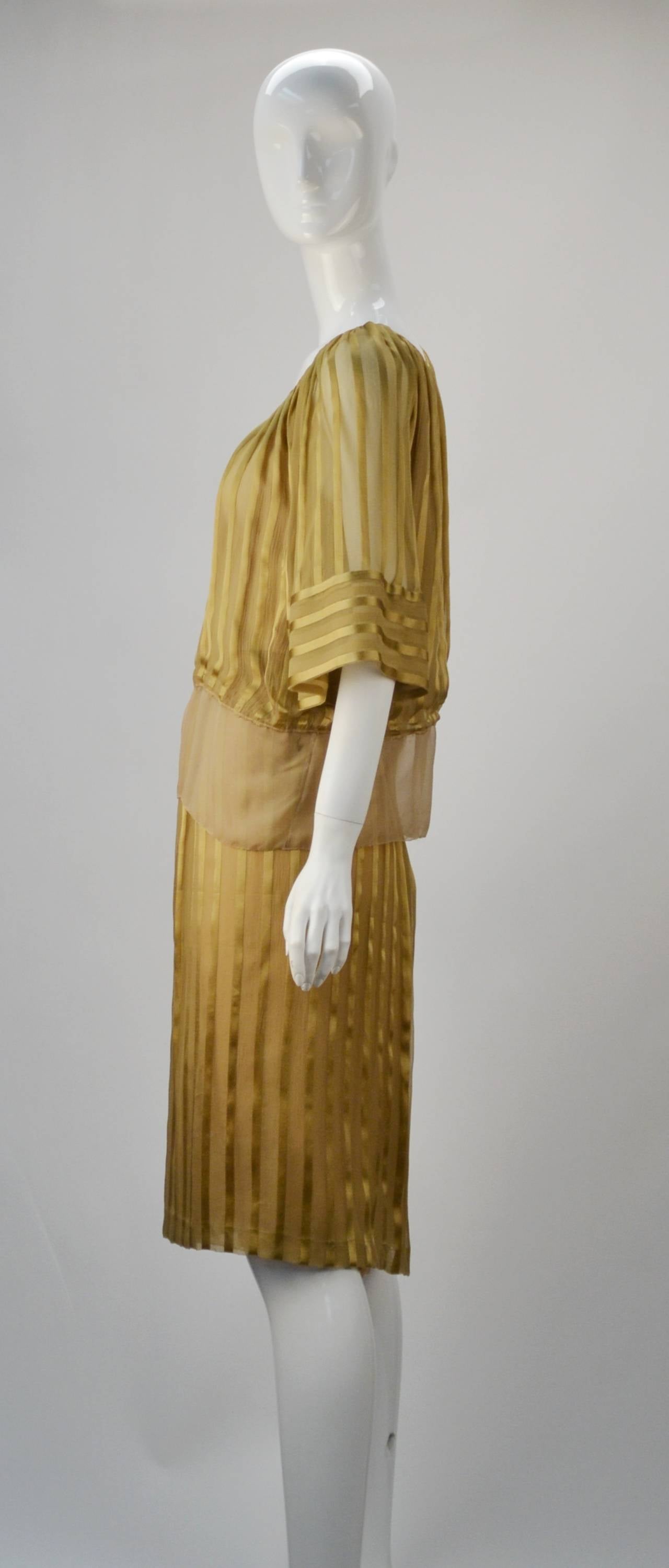 This brilliant Mollie Parnis is so elegant, so perfect for summer, and so perfect for day to evening wear. Great individual pieces to be worn as separates consisting of a gold striped skirt and a peasant blouse. We love the blouse with a pair of