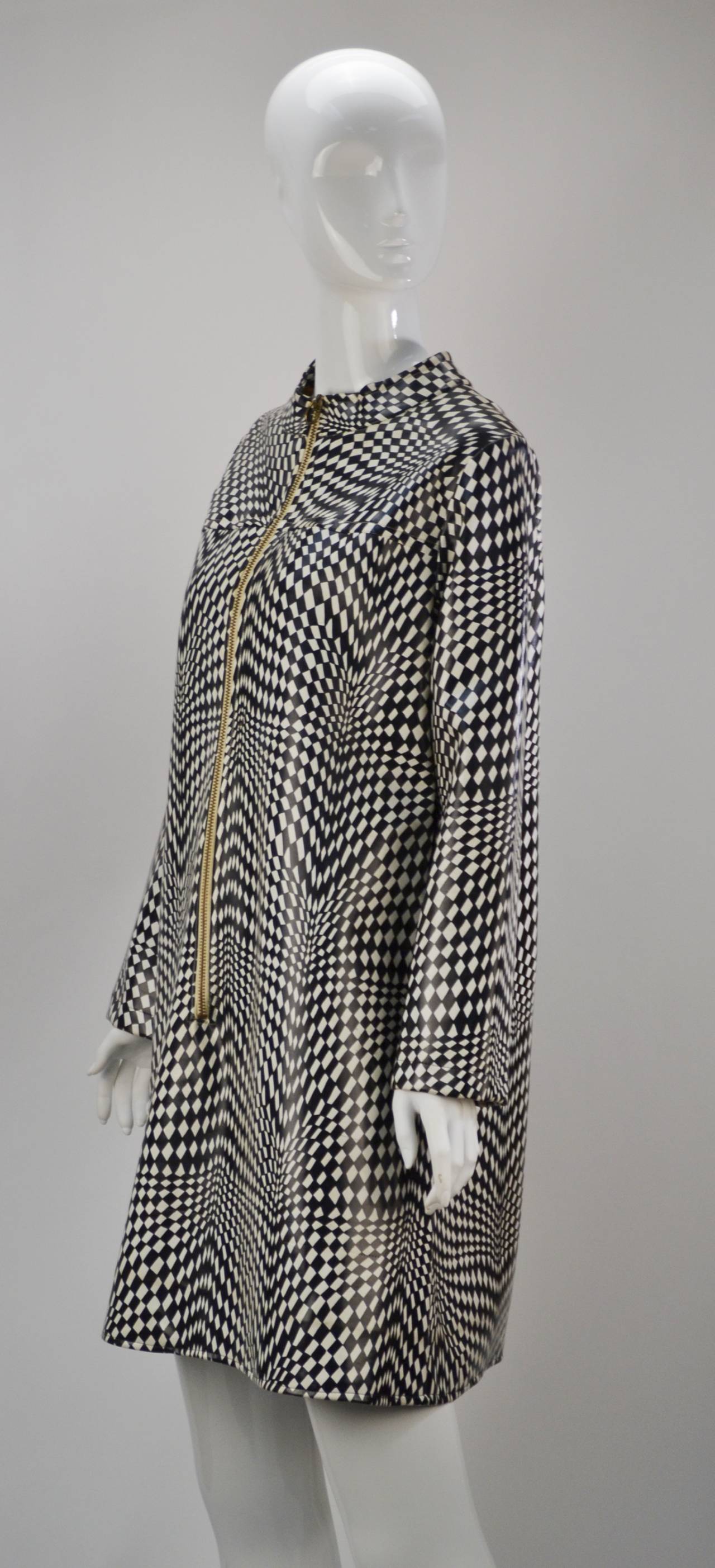 Edgy vinyl equals instant style (and protection from the Rain)! 1960's mod black and white psychedelic checker print with front zipper. Long sleeves and collar band A-Line dress/raincoat.

A MRS. Couture favorite!

Modern size 6/8.

*All