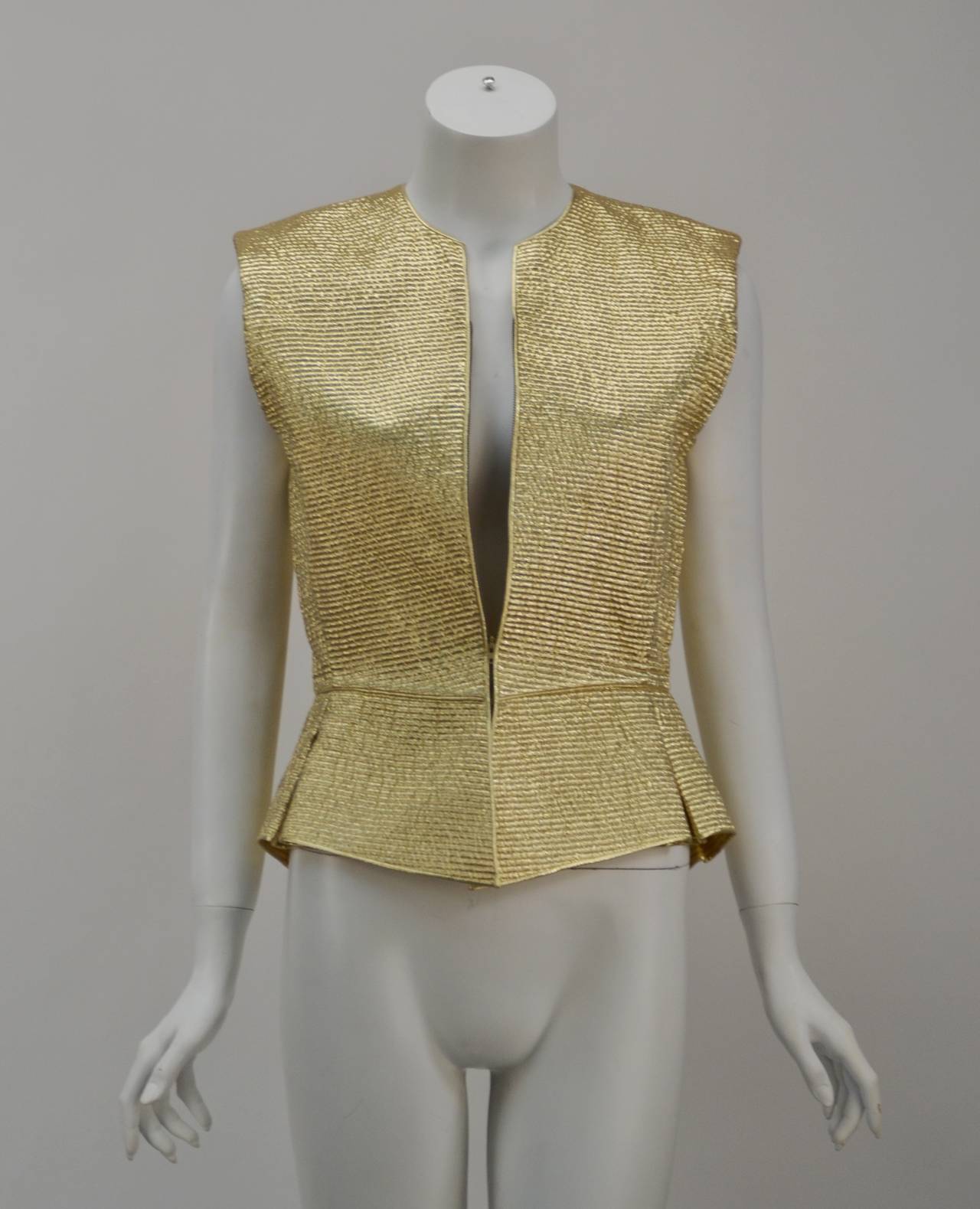 Mary McFadden is known for her exotic designs. This quilted gold peplum top is no exception. Dress it up or down. Wear as vest or a top.  Zipper front and sleeveless. Add a pair of jeans and platforms, a pencil skirt and peep toes or even shorts and