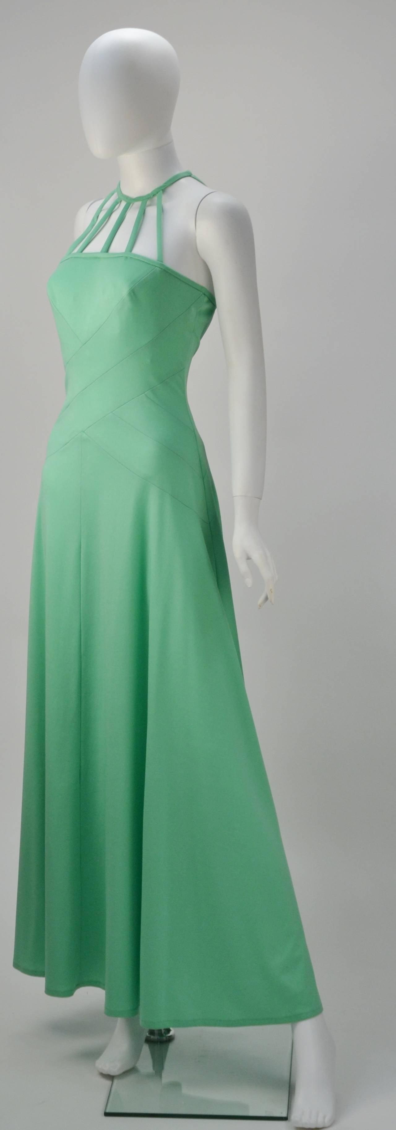 We can hear a tropical destination calling and this Gillian Paul mint green halter dress will be in the suitcase. Jersey with a back zippered closure, as well as two hook-n-eye closures. Uber sexy caged halter detail and the criss-crossed lines.