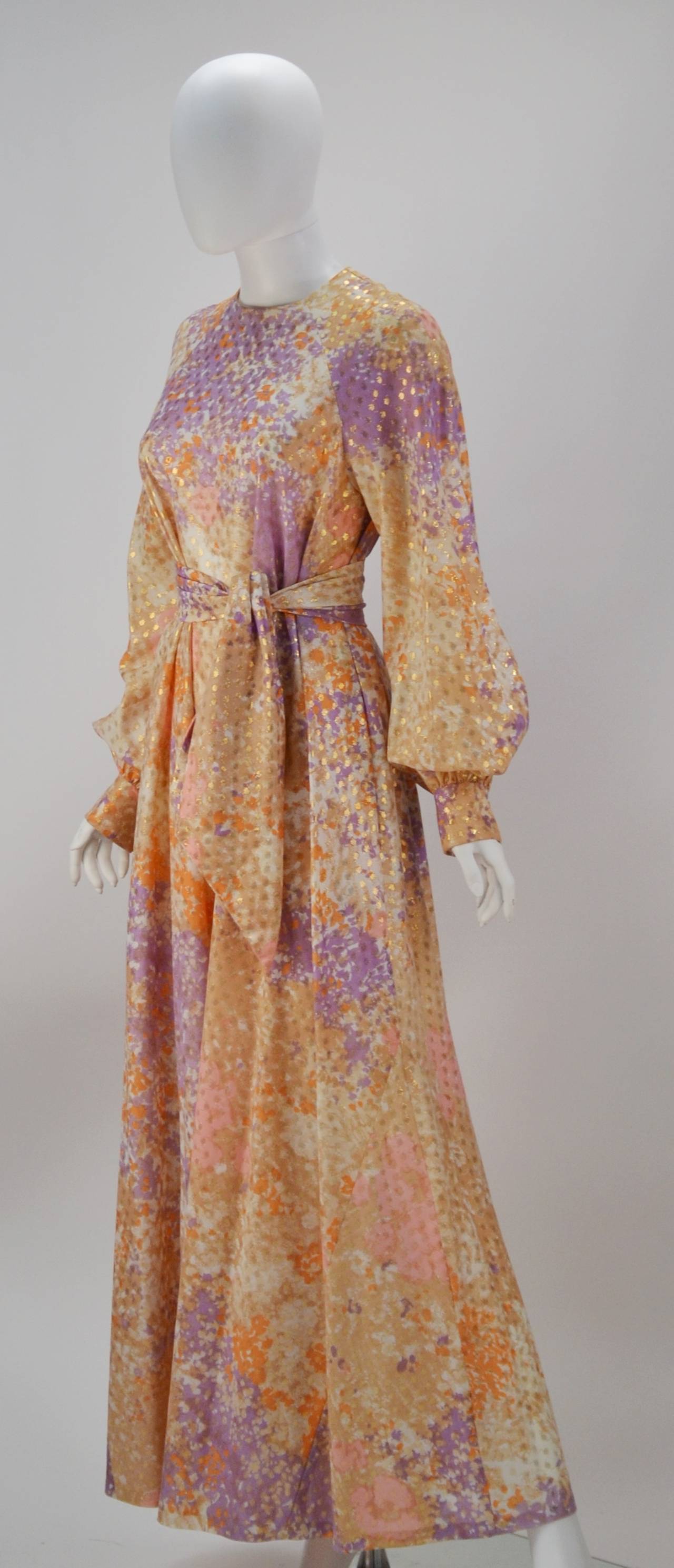 Chic, Colorful, and Comfortable!  1970's Bill Tice multi-colored long sleeve kaftan with sash has gold detailing throughout the garment. The bishop sleeves have an elegant cuff with gold glittered buttons. There is a zippered back closure and 