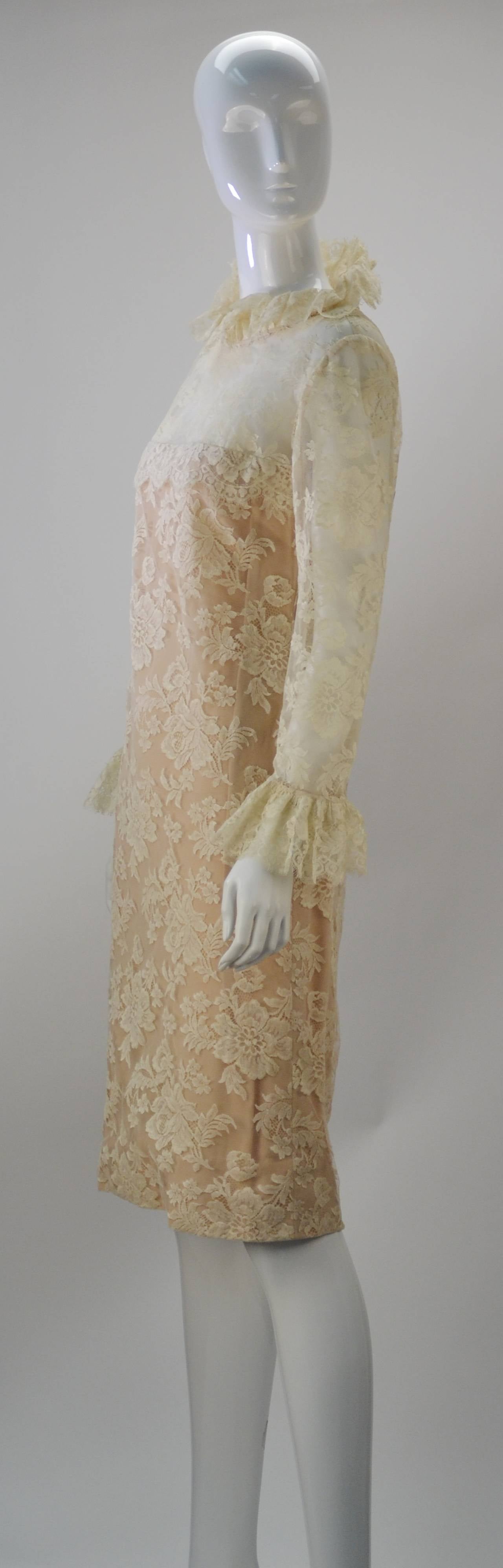 1960's Bill Blass for Maurice Rentner ivory long sleeve dress with Chantilly lace overlay screams Victorian with its ruffle neck. The sleeve hems also offer a whimsical ruffle detail, giving the dress added femininity. The dress fastens by a back