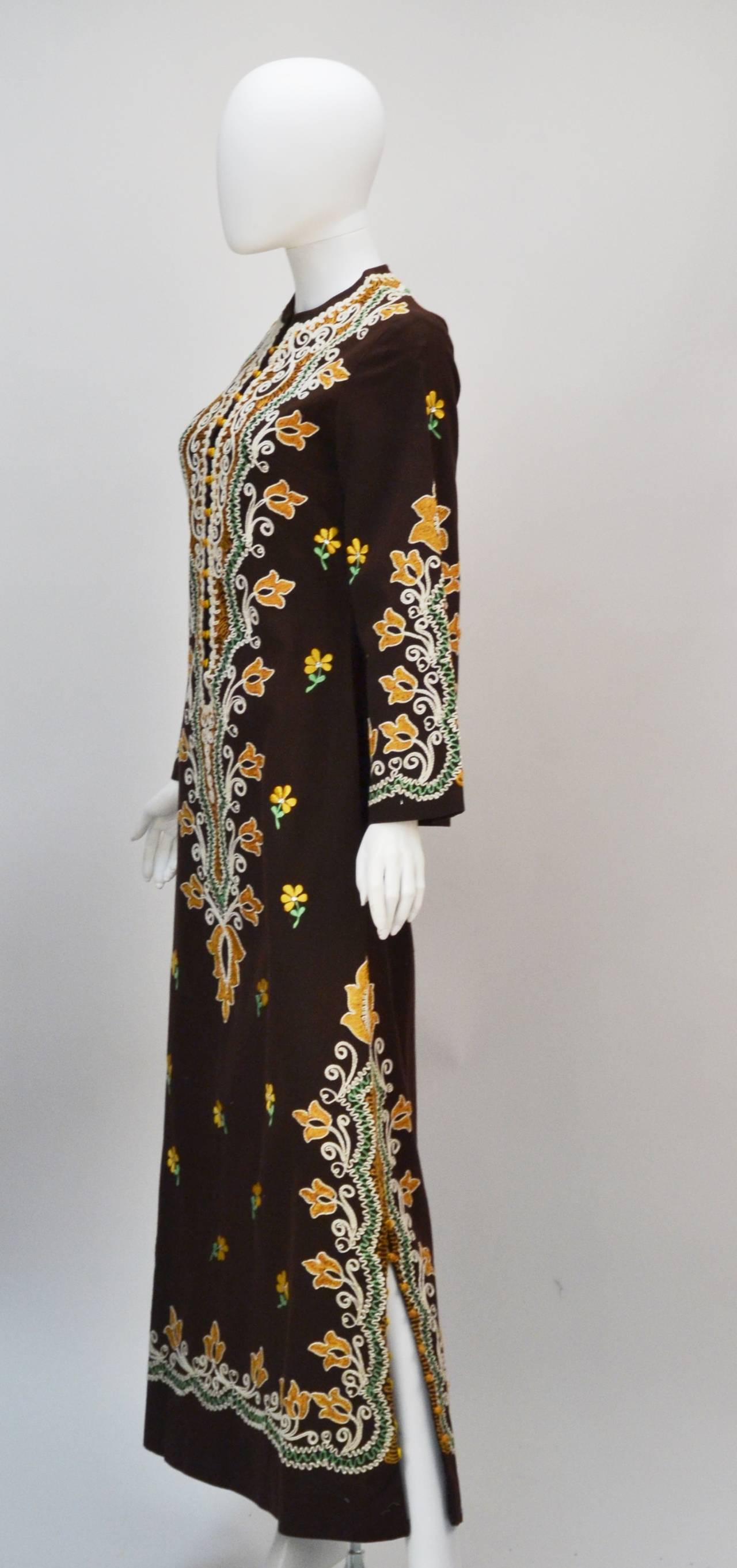 "Absolute Comfort" Maxi in a traditional style, this kaftan is perfect for an exotic getaway or a day playing homage to ethnic artistry. 1970's unlabeled ethnic brown long sleeve caftan with beautiful and unique hand stitched floral