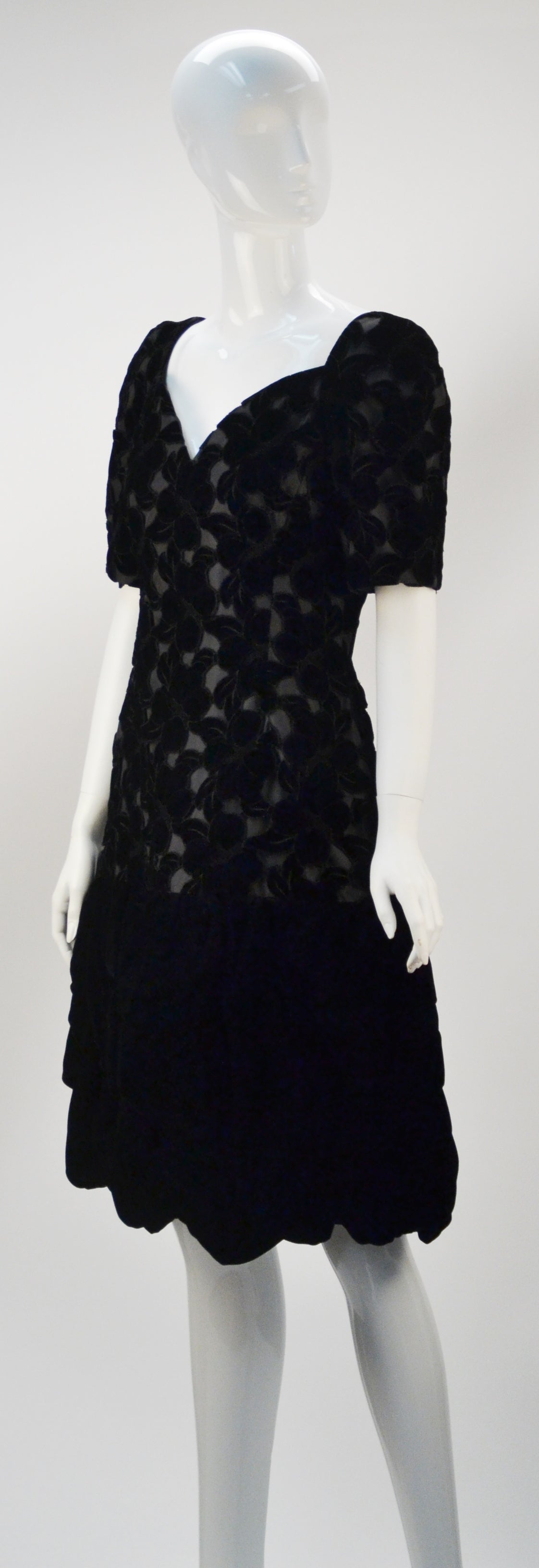 Gorgeous 1990's Scaasi black laser cut velvet floral print cocktail dress with short sleeves. The bodice has a sweetheart necklace and hidden boning to the true waist. The laser cut bodice creates a drop waist silhouette, while the velvet skirt is