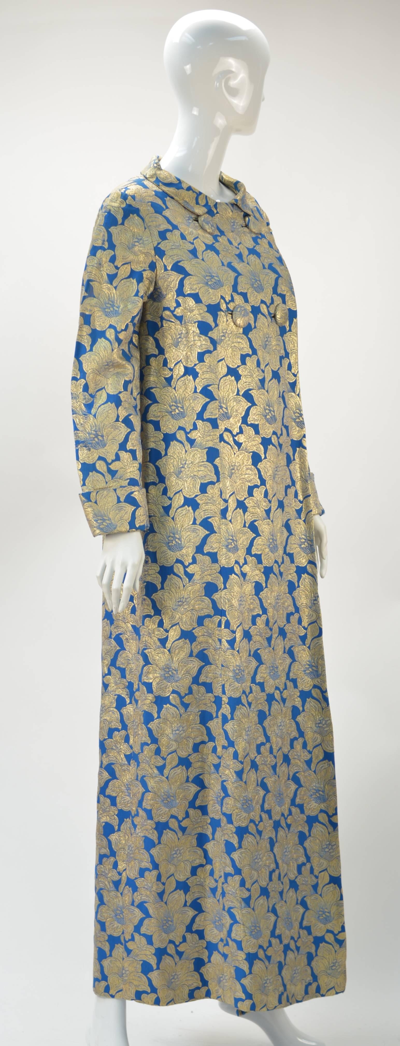 Gorgeous 1960's Blue with gold metallic floral print brocade long evening coat. Make a statement at any party this year. Wear it as your dress with something covering that which you might want hidden underneath. We've paired it with a skin tone cat