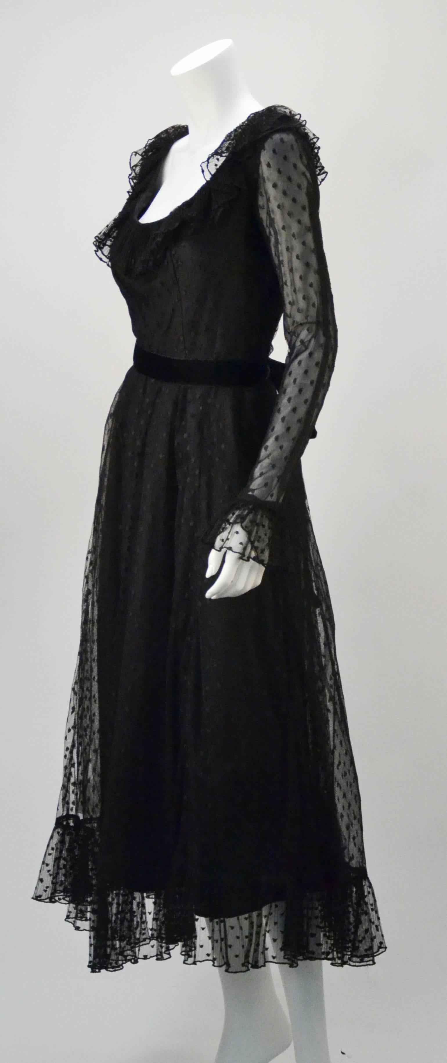 Sweet and feminine with a little femme fatale, 1970's black long sleeve evening dress with lace polka dot overlay by American Designer Victor Costa. The sleeve and skirt hems have a ruffled silhouette. The sleeves also have a snap closure at the