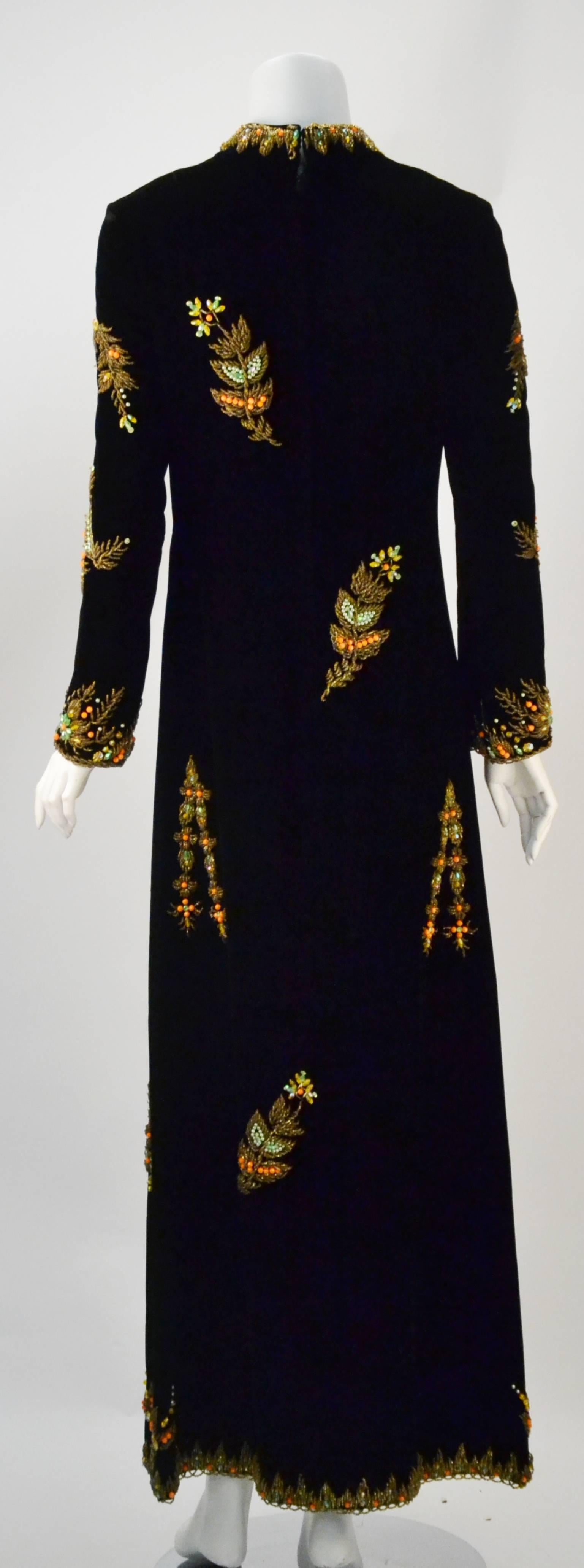 Must see to believe!  

Stunning black velvet with hand beadwork and embroidery ethnic inspired evening dress. It features long sleeves and a semi-scooped neckline. Its slightly raised collar sits on the neck perfectly. The dress fastens with a