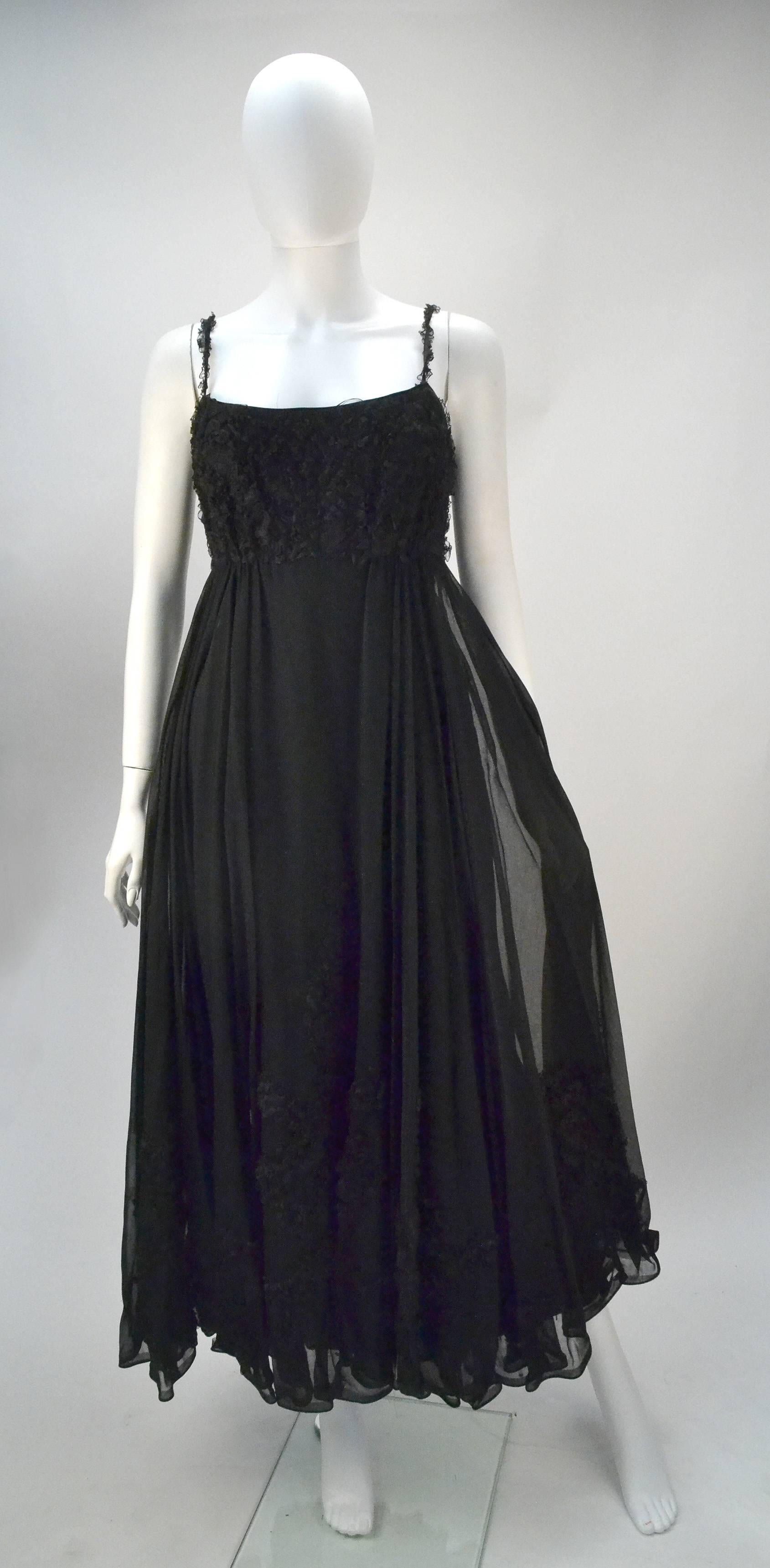 1960's Mr. Blackwell Custom black cocktail dress with spaghetti straps and circle skirt. The dress is an absolute 60's dream with it's ruffle trim at the bust, along the straps and forms a decorative pattern on the top layer of the skirt. The dress