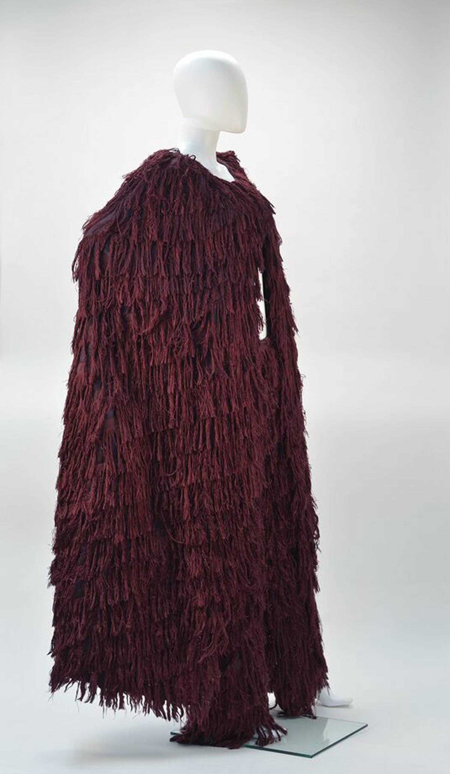If you're looking for a statement outfit, this is definitely the one.
A Mila Schon dramatic burgundy silk fringe ensemble, comprised of a burgundy silk cape with a silk fringe motif, together with a fantastic matching fringe pant.  

The silk