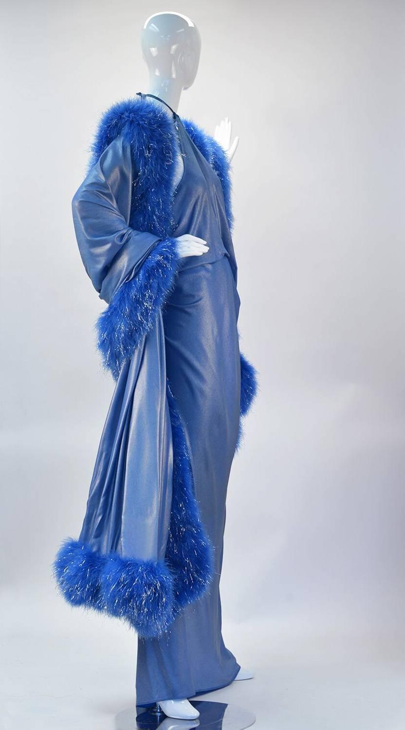 This custom gown was produced by designer Renato Balestra and graced the cover of all Ebony Fashion Fair advertisements for the 1994-1995 event.  Long flowing metallic blue maxi halter dress has an inner belt creating a blouson draped bodice. Snap