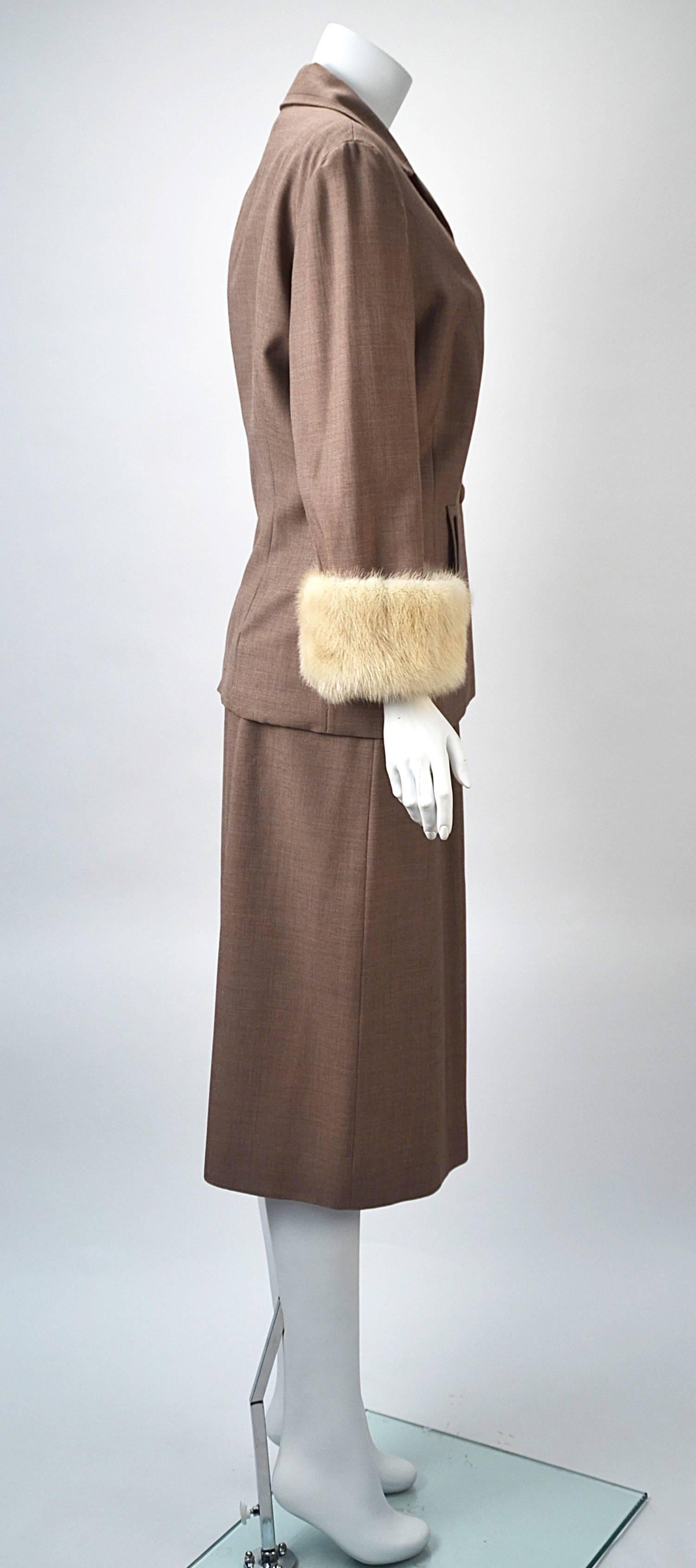 We don't often collect or sell suits, but we love this one!!!

Beautifully tailored hazelnut gabardine skirt suit with white mink cuffs on three quarter length sleeves from Neiman Marcus. Design details in this suit are reminiscent of the 1940's