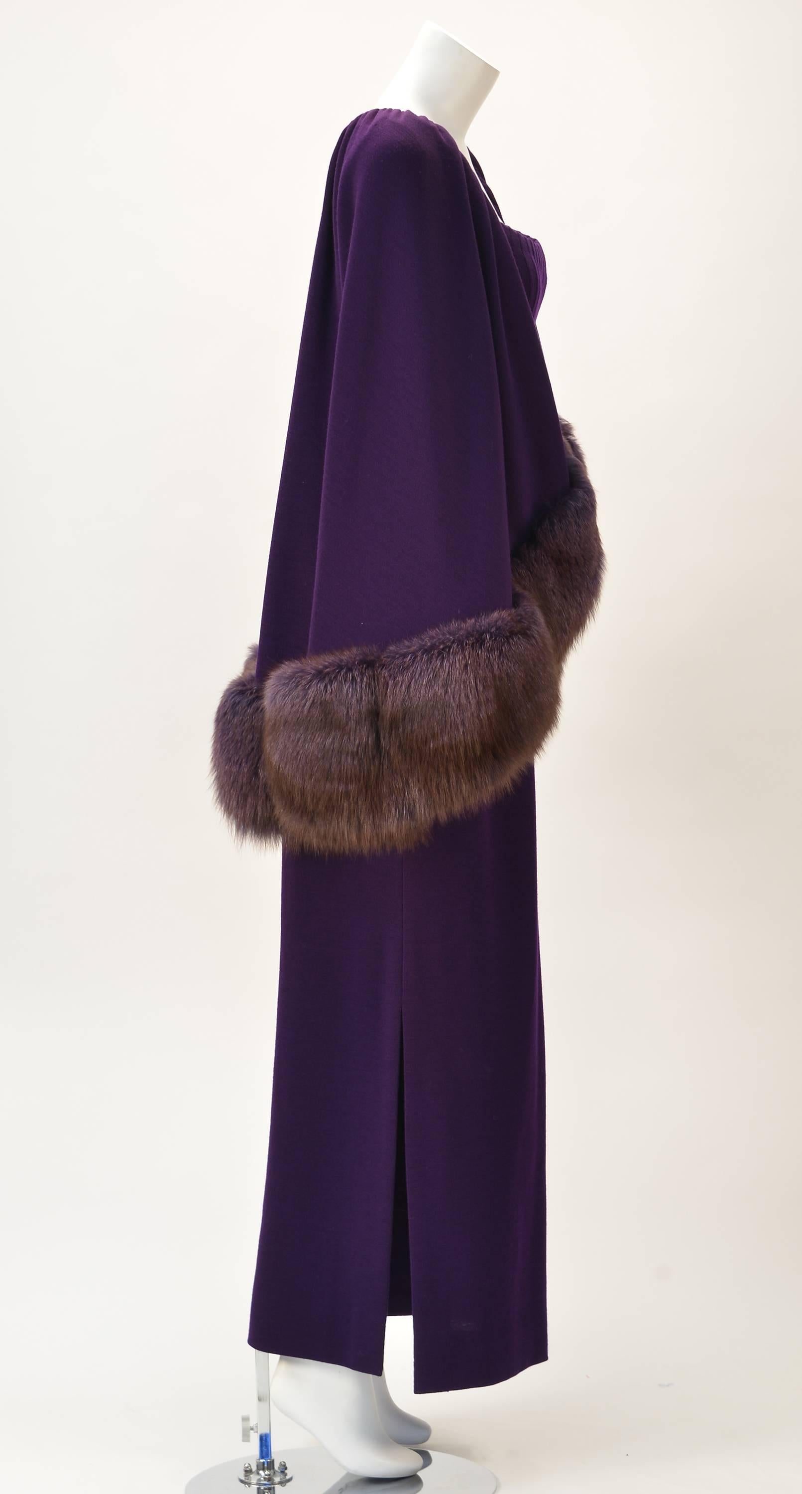 Signed and numbered, comes this stunning purple Pauline Trigere dress and fur trimmed cape. The long, wool blend dress is a rich royal purple with spaghetti straps and a pleated bodice with side slits. There is an inner belt and side zipper.

The