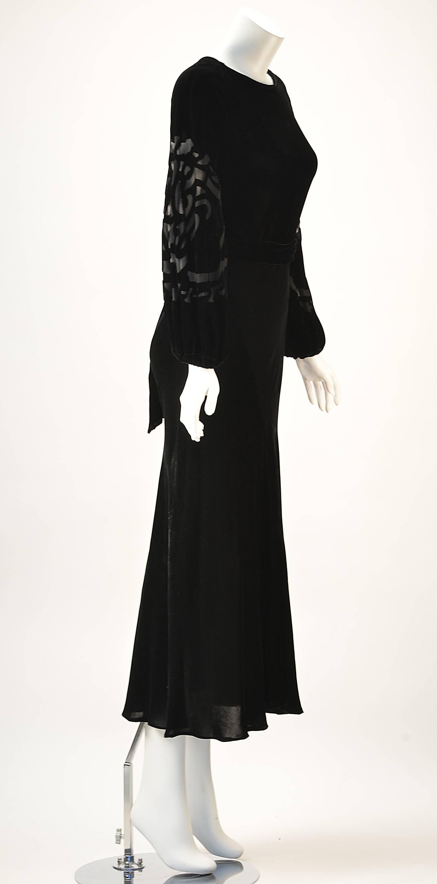 Beautiful bias cut black velvet dress with bishop sleeves. The bias cut velvet hugs the shape of your body while the silk burn out sleeves add romance. There is a velvet belt that ties at the back. It has a Boat neckline with a slight weighted drape