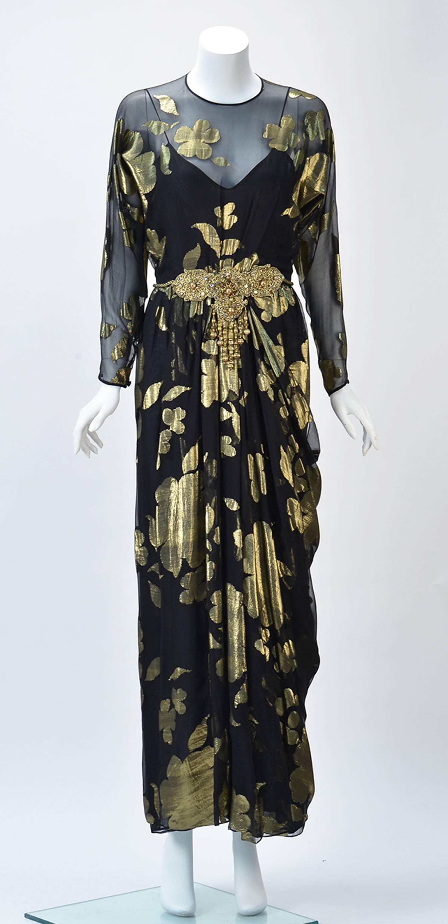 Dynamic Asian and Indian inspired Oscar de la Renta sheer black with metallic flower dress ensemble. Intricately designed with delicate details.

Dress: Long black sheer with metallic gold flowers dress with long bat-wing sleeves button at cuff.