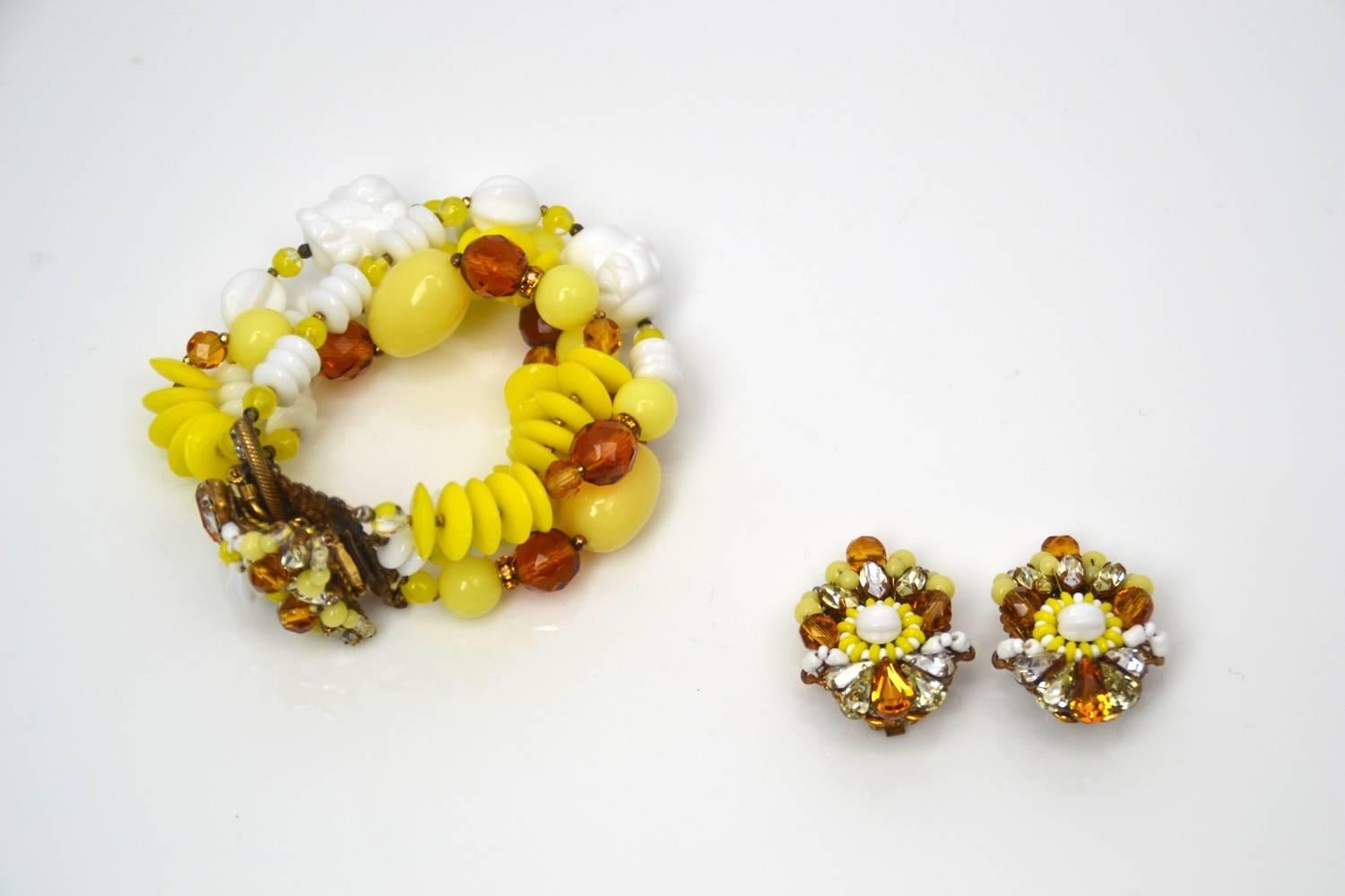 Eclectic, vibrant and vintage. Designed by Eugene Schultz in the 1950's, this demi parure has yellow, white and burnt orange glass beading with coordinating rhinestones. Earring beads and stones are set in a gold-tone filigree setting. Bracelet has