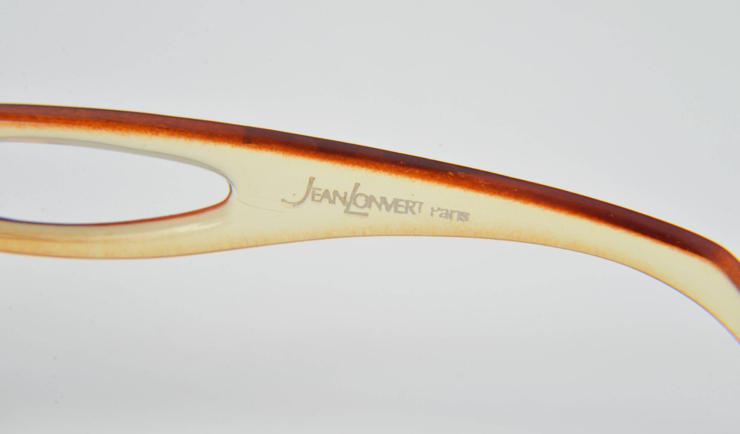 Late 1960's (possibly early 1970's) fashion forward Jean Lonvert Paris square framed sunglasses with rounded edges. The frames have a dark brown border that fades into a clear light yellow hue. The lenses have a brown gradient. One of the temples is