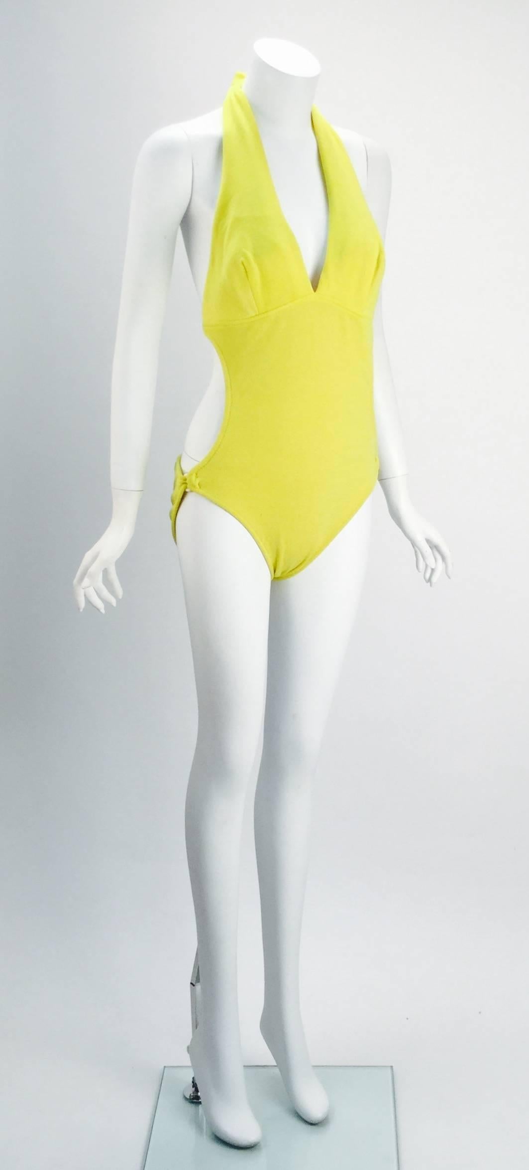 
1960's Brigance for Sinclair yellow monokini. Suit has a halter top that ties around the neck as well as a back strap for support. Back strap hooks onto the right side. Two cut outs on side of swim suit. Two rings on each hip 

Modern size 4/6.