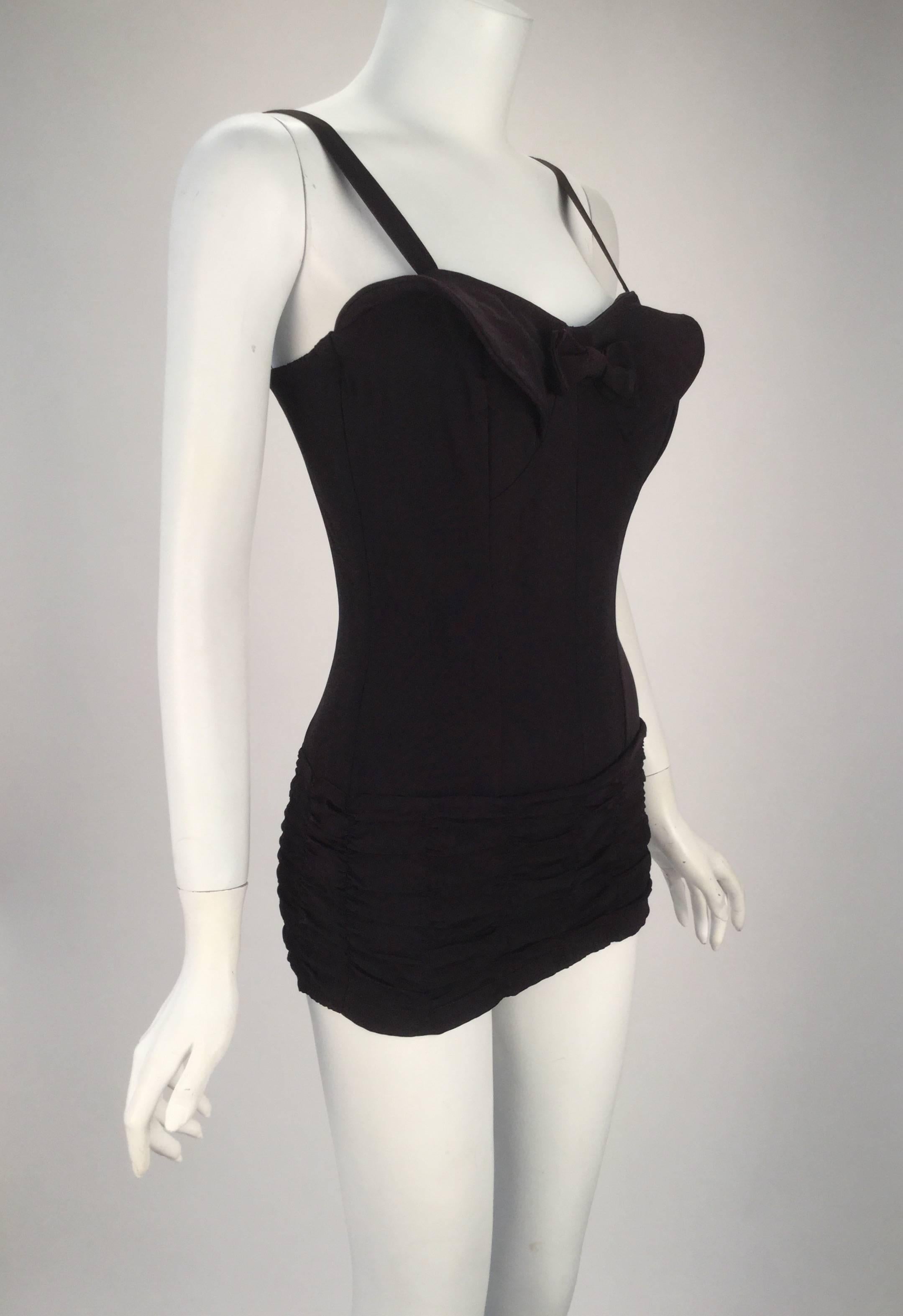 

1950s Maurice Handler Black one piece bathing suit. Like most bathing suits of the 50s, this one features an hourglass silhouette, complete with boning along almost every seam. The straps are detachable from the back. There is ruching detail at