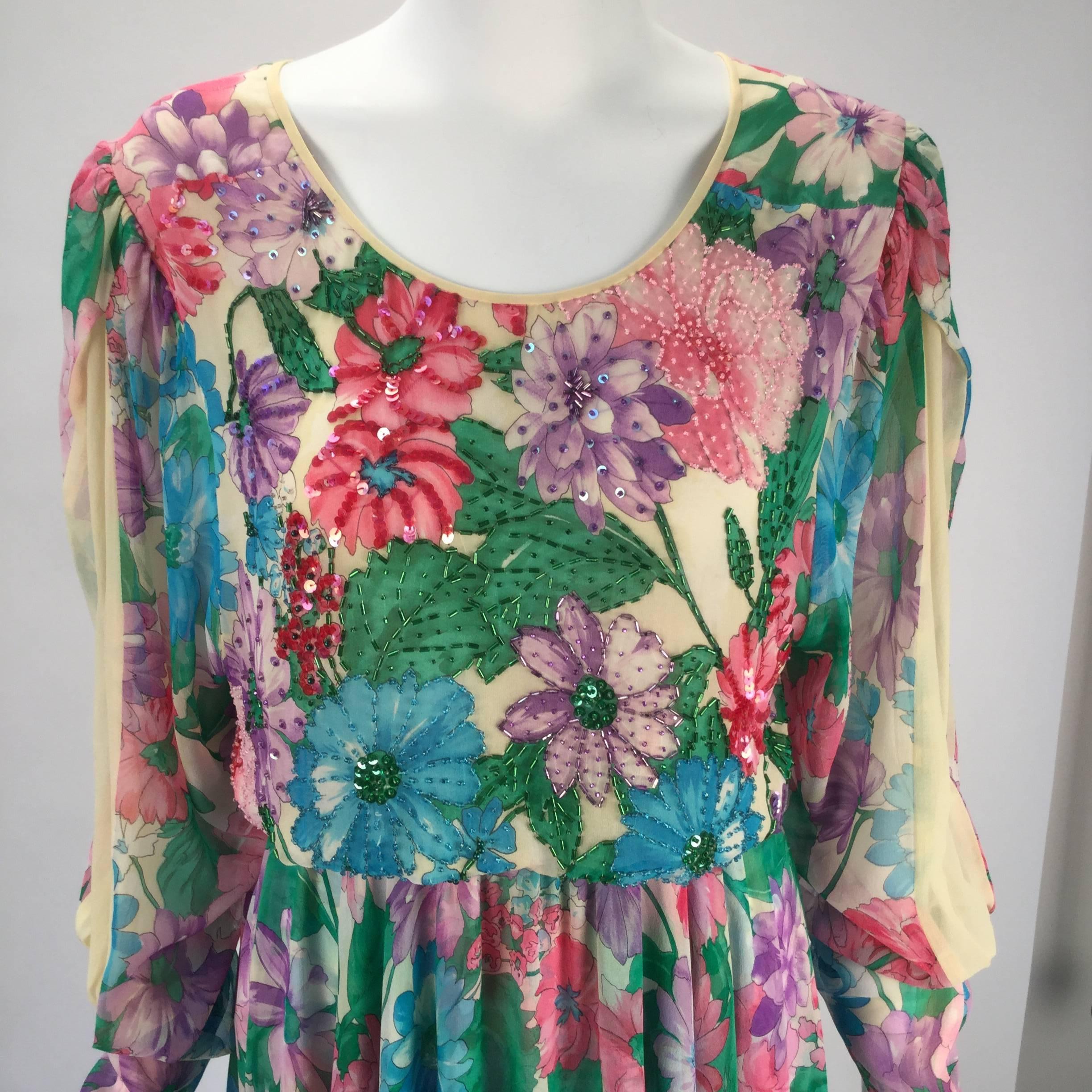 1980s Diane Freis silk long sleeve multicolor floral dress. The semi-sheer dress features a scoop neckline and a blouson silhouette from the bust to the waist. The waistband has elastic that has a ruching technique, which creates a gathering effect