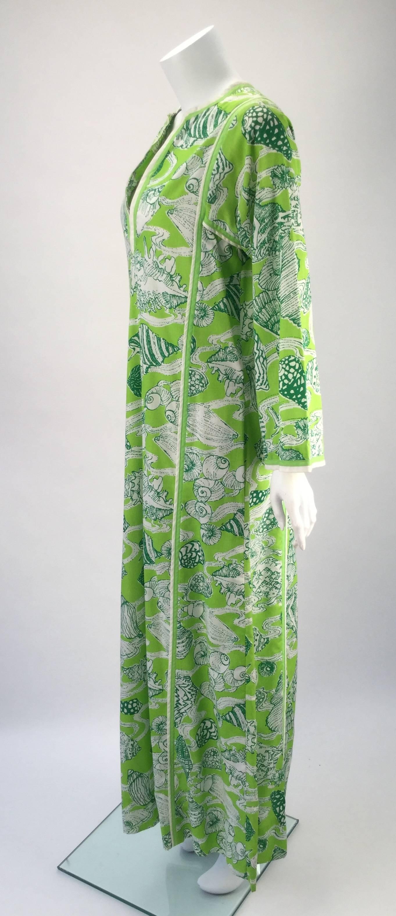Fantastic early Lilly Pulitzer kaftan from the mid 1960s/early 1970s. The kaftan is lime green with green and white sea shell print.  The front of dress dips into a deep-V that can be closed with two hook and eye closures. Seam binding detail all