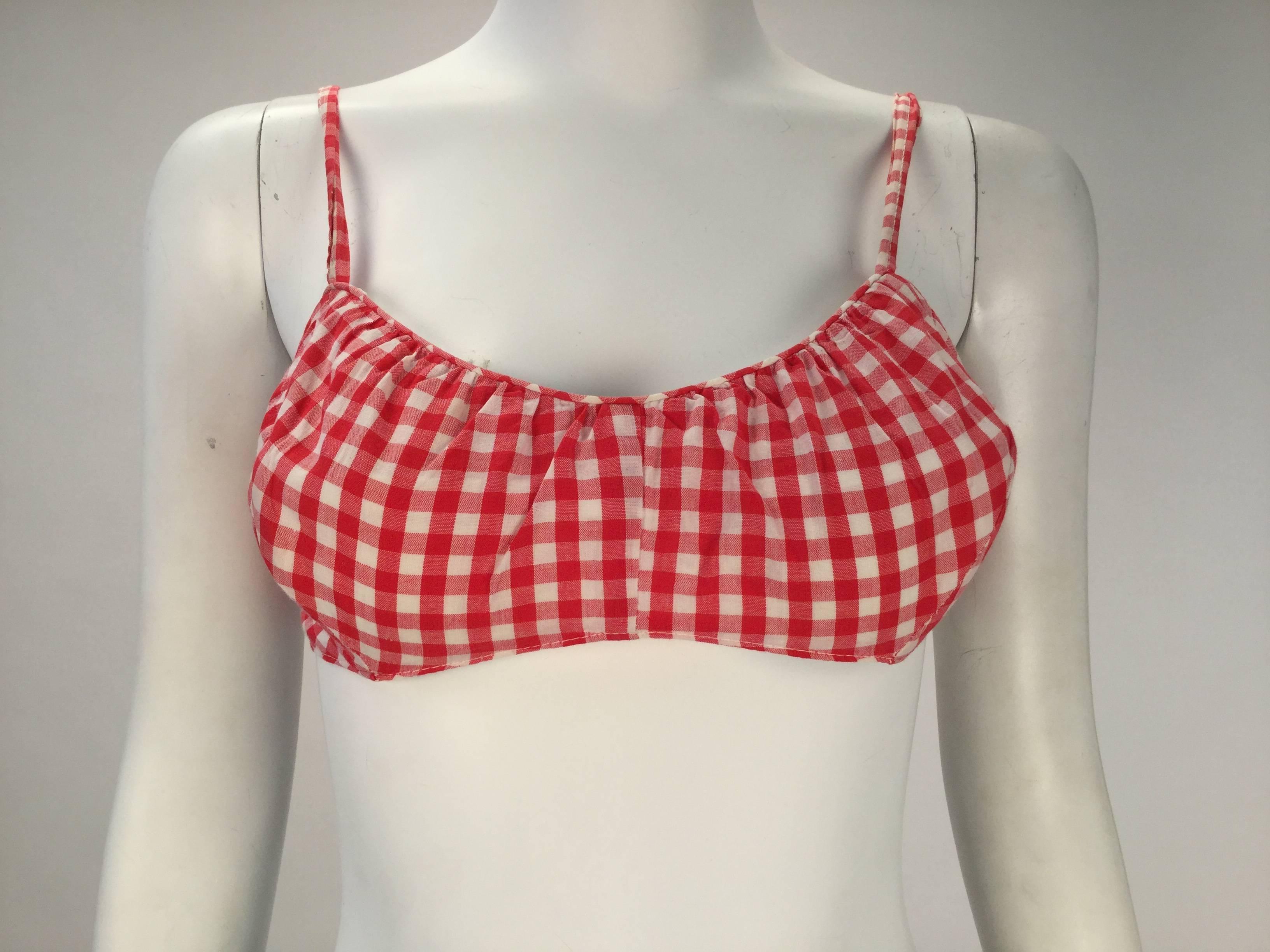 
Chic 1960's Cole of California white and red checkered print bikini with matching headband. The top has thin straps and a side two button closure. It is also lined, and includes bust support. The bikini bottom is also lined and has an elastic