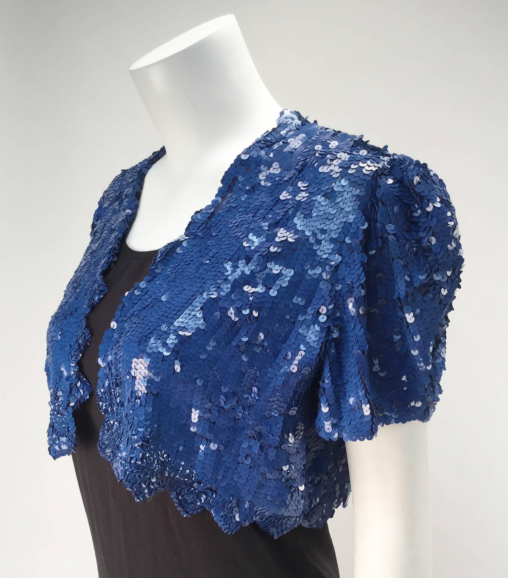 Wonderful vintage short sleeve bolero with blue sequins. Dress it up or dress it down... just dress in it!  This piece is absolutely fantastic!!!!

Our staff is arguing about whether it looks best over our black Norma Kamali jumpsuit or with a