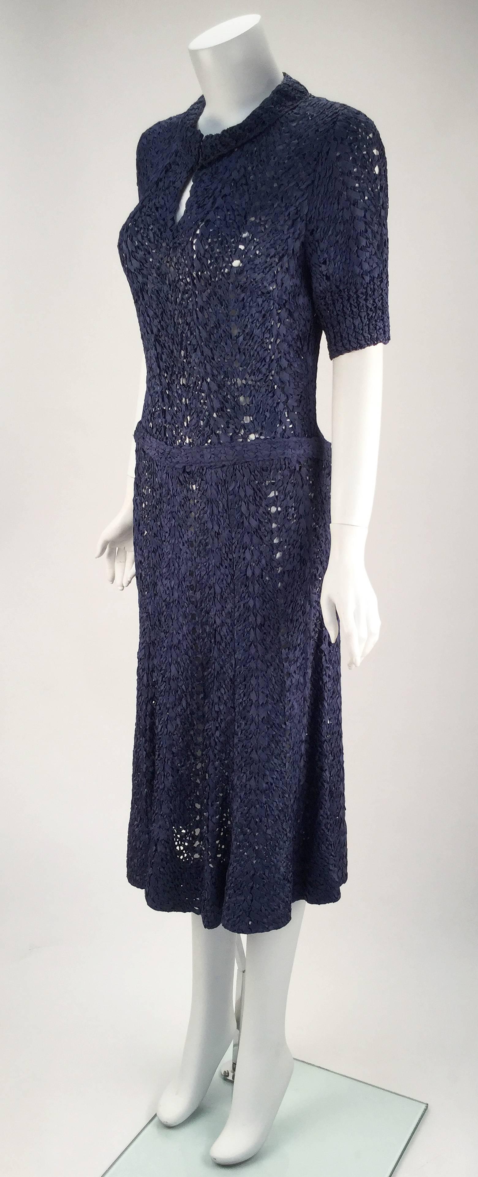 
Unbelievable handwork -- 1940s navy blue silk ribbon knit unlined knee length dress with short sleeves. Elegant ribbing details border the sleeves and scoop collar. Key hole at center front with two hook and eye closures at center front neck. Side