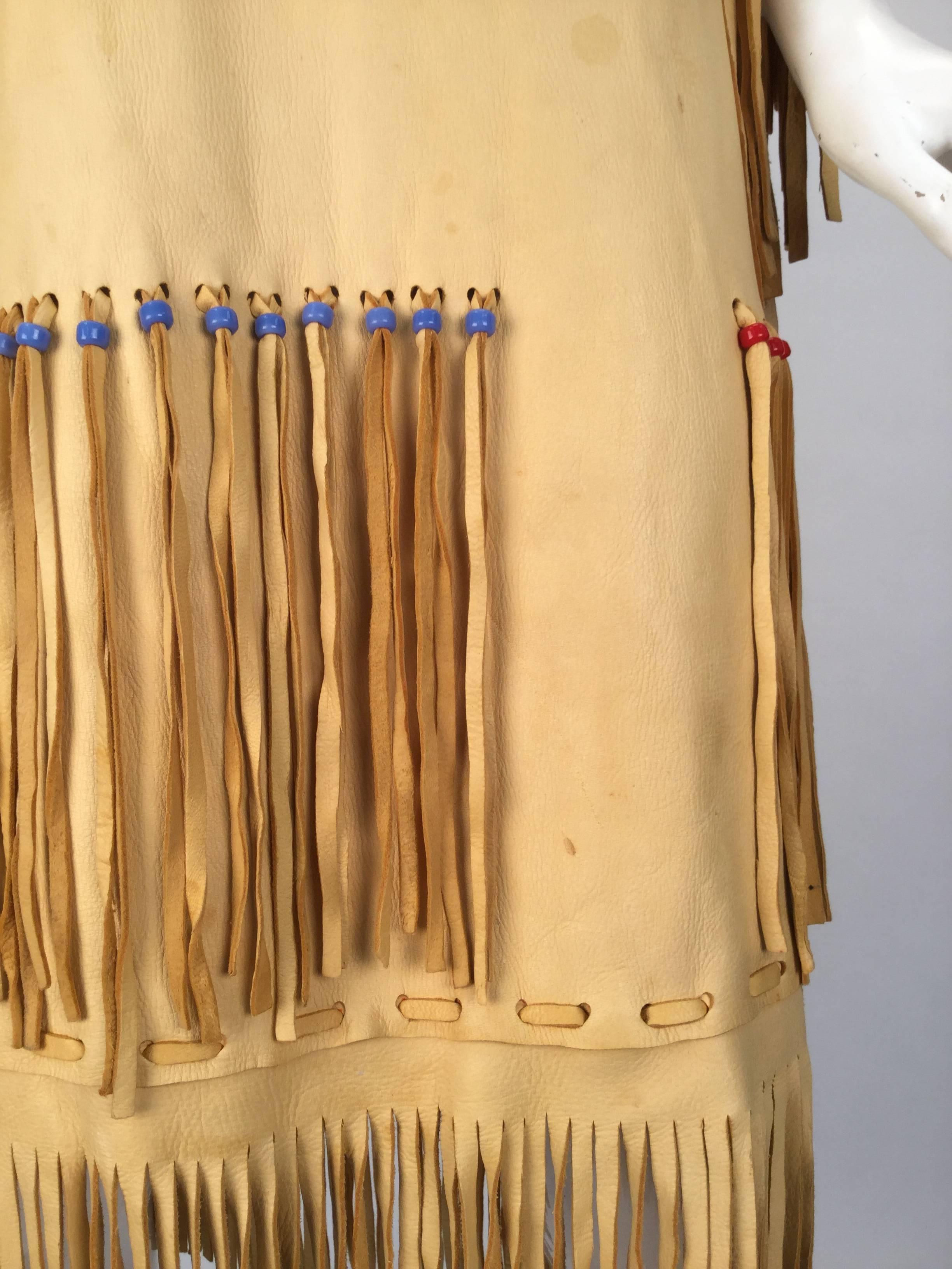 Unbelievable Native American style leather handmade and hand painted fringe dress complete with beading around the fringe hanging from the arms and bottom of the skirt. Completed with a floral hand painted image on the front and the back neckline.