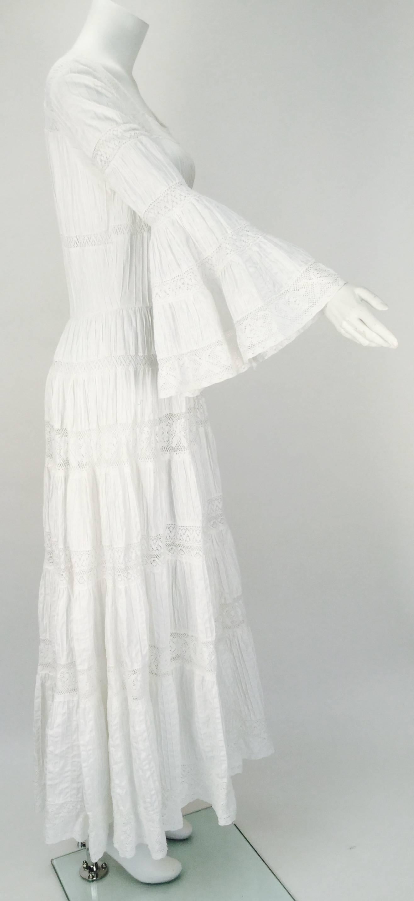 Perfect for a beach wedding or when you just want to channel some of your inner ethnic bohemian comes this 1970's white cotton dress with pintucking and crochet lace inserts. The dress was made in Mexico for Fred Leighton. Three quarter length