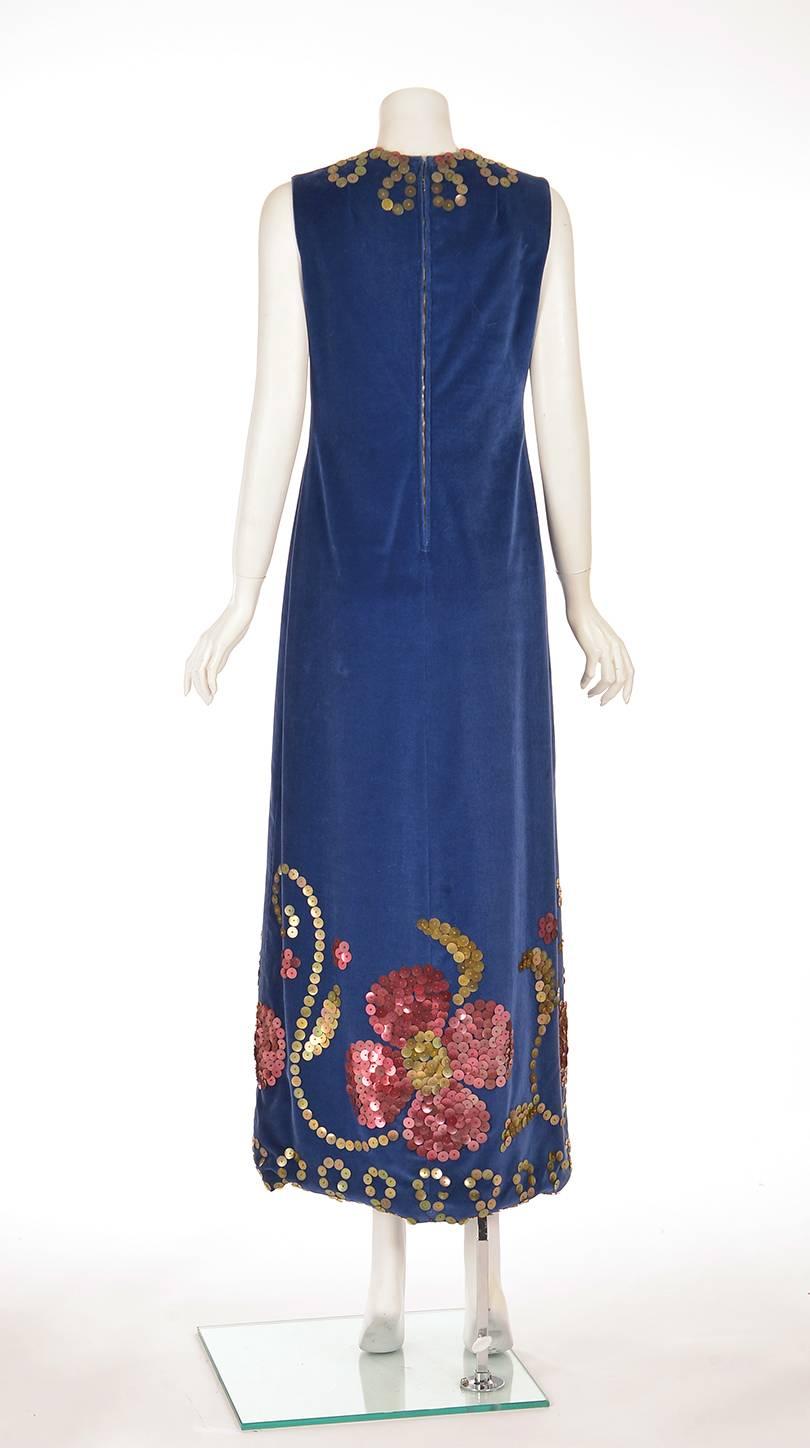Bohemian 1970's maxi dress. This gorgeous dark blue velvet maxi dress is sleeveless, and has a V-neck. The dress is adorned with large pink and gold-tone shell sequins and seed beads in a floral and swirly design. The dress has a twenty inch slit