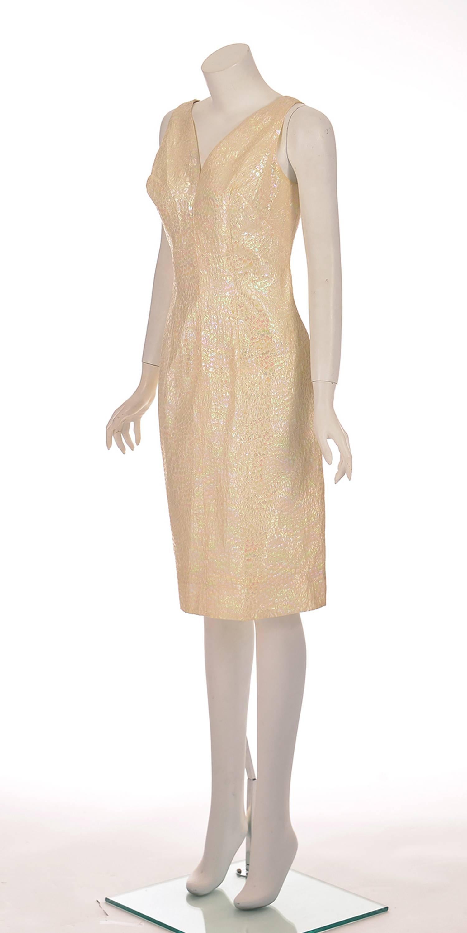 1970's California Brand Lilli Diamond cocktail dress. This gorgeous white pearl iridescent dress features an organic scale-like pattern that shines like a rainbow. The sleeveless dress has a deep V-neck in both the front and back, and has a center