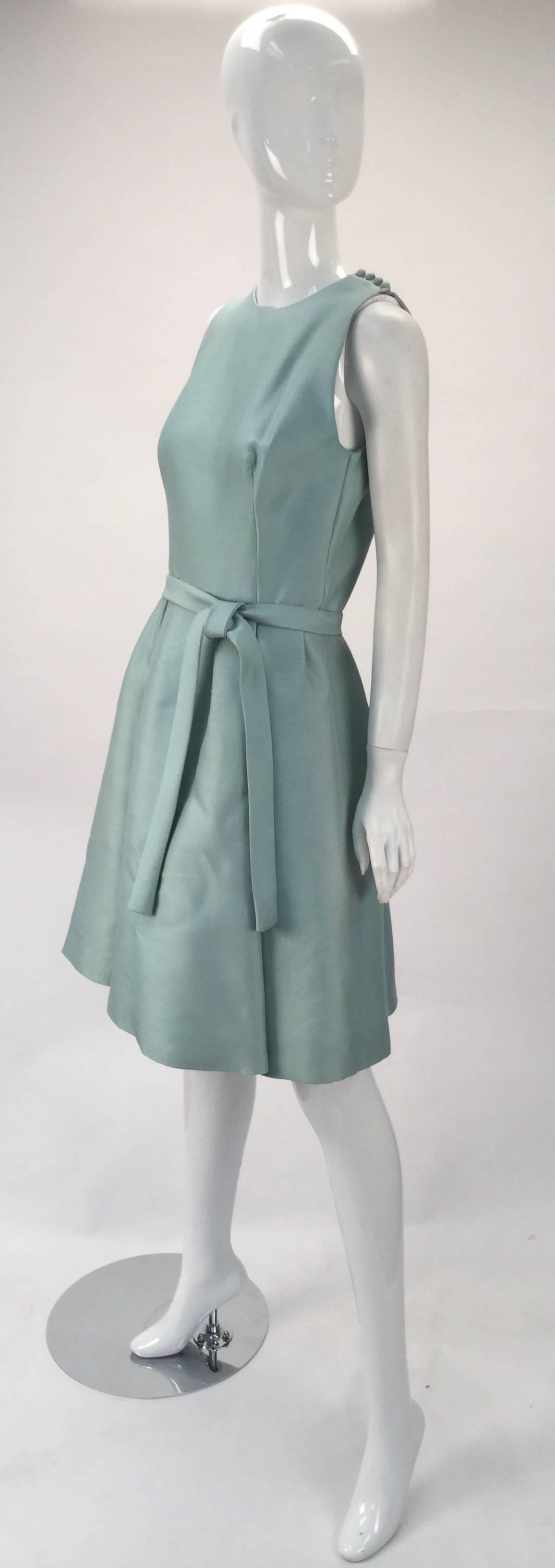 Adorable and beautiful 1960's silk seafoam green sleeveless midi dress by Geoffrey Beene. Cocktail or day wear.  Silk fabric is interlined. Self fabric belt for tying at the waist. Box pleated skirt. Bust darts. The shoulder seams have fabric