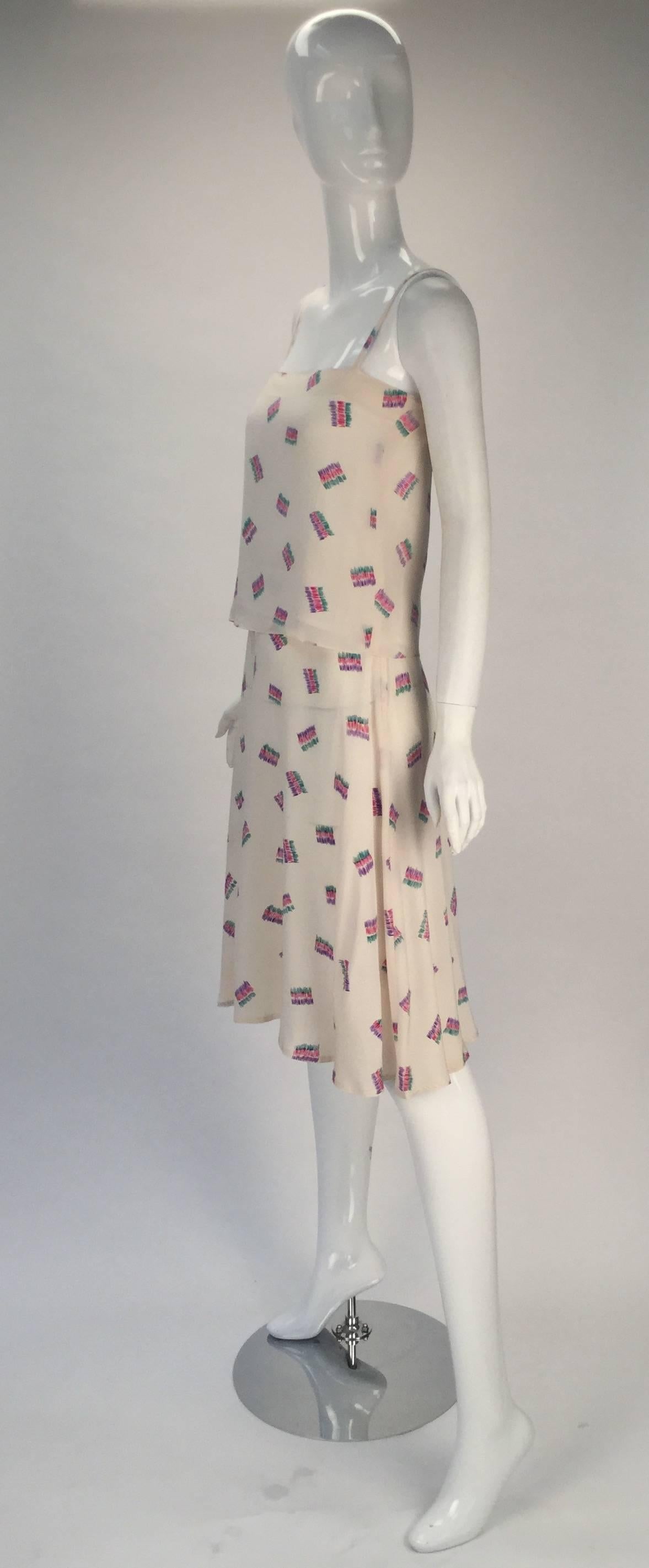 Perfect this summer and worn as an ensemble or worn as separates comes this fun 1980's Diane Von Furstenberg off white silk two piece tank top and skirt ensemble. Multicolored squiggle designs that form rectangles. The top is lined (not by