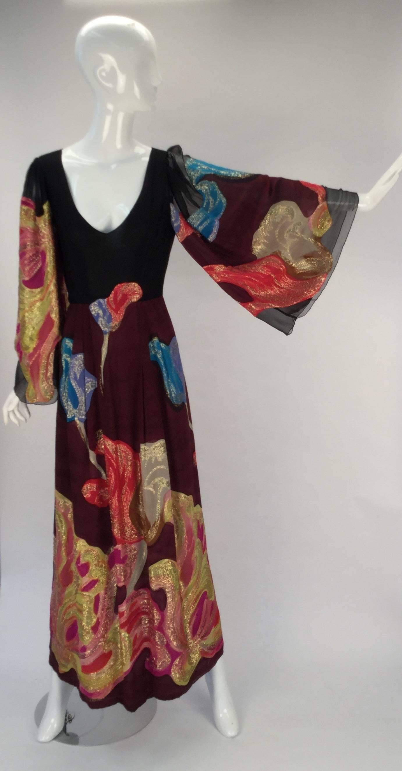Exquisite late 1970s Pauline Trigere silk multicolored evening dress with gold metallic threading. Wonderful abstract design throughout with metallic threads. Semi sheer. Long sheer butterfly sleeves. V neckline. Skirt is lined with a sheer fabric.