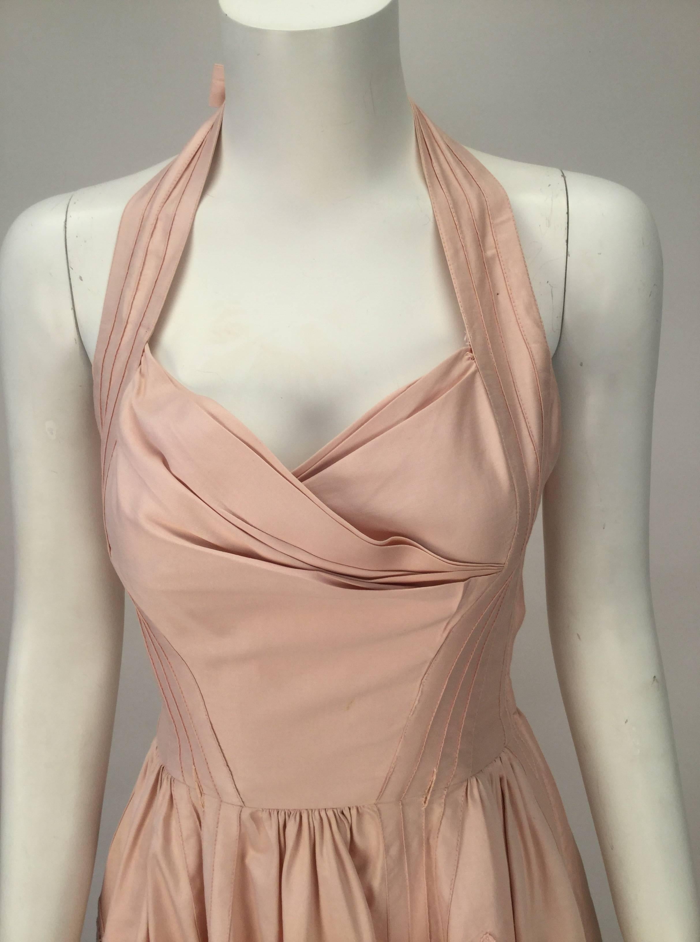 Summer beach movies and 50's cotillion teas are what come to mind when we think of this pale pink dress. Dress ties around the neck creating a halter top. Sweetheart neckline. Gathered at bust line. Gathers also at the waistline adding softness to