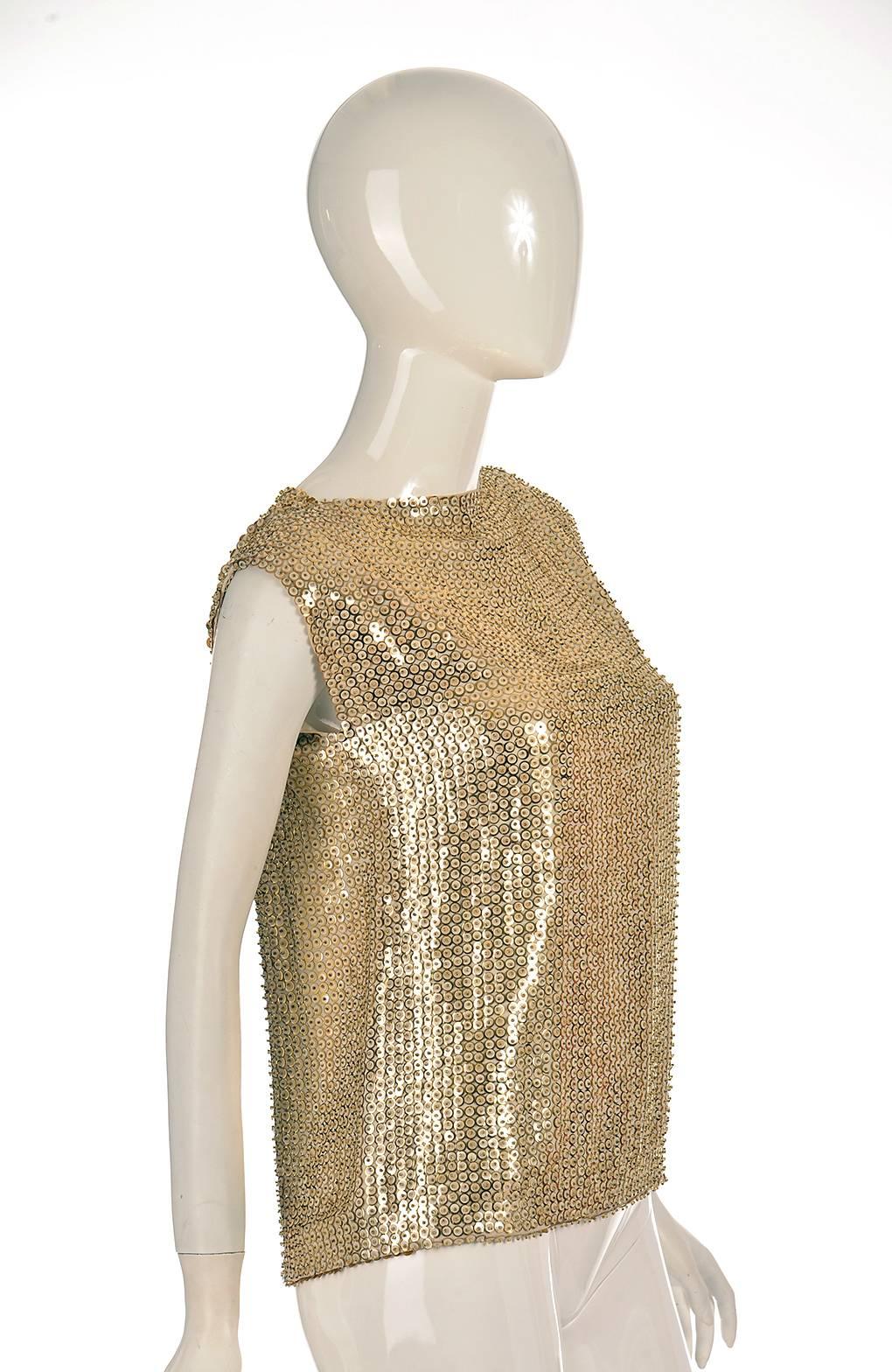 Vintage Pierre Balmain Mesh Top is gorgeous gold and white and fully sequined.  It has a white voile fabric base, supporting rows and columns of sequins. The sequins themselves are primarily white with a gold-tone border, and are topped off with