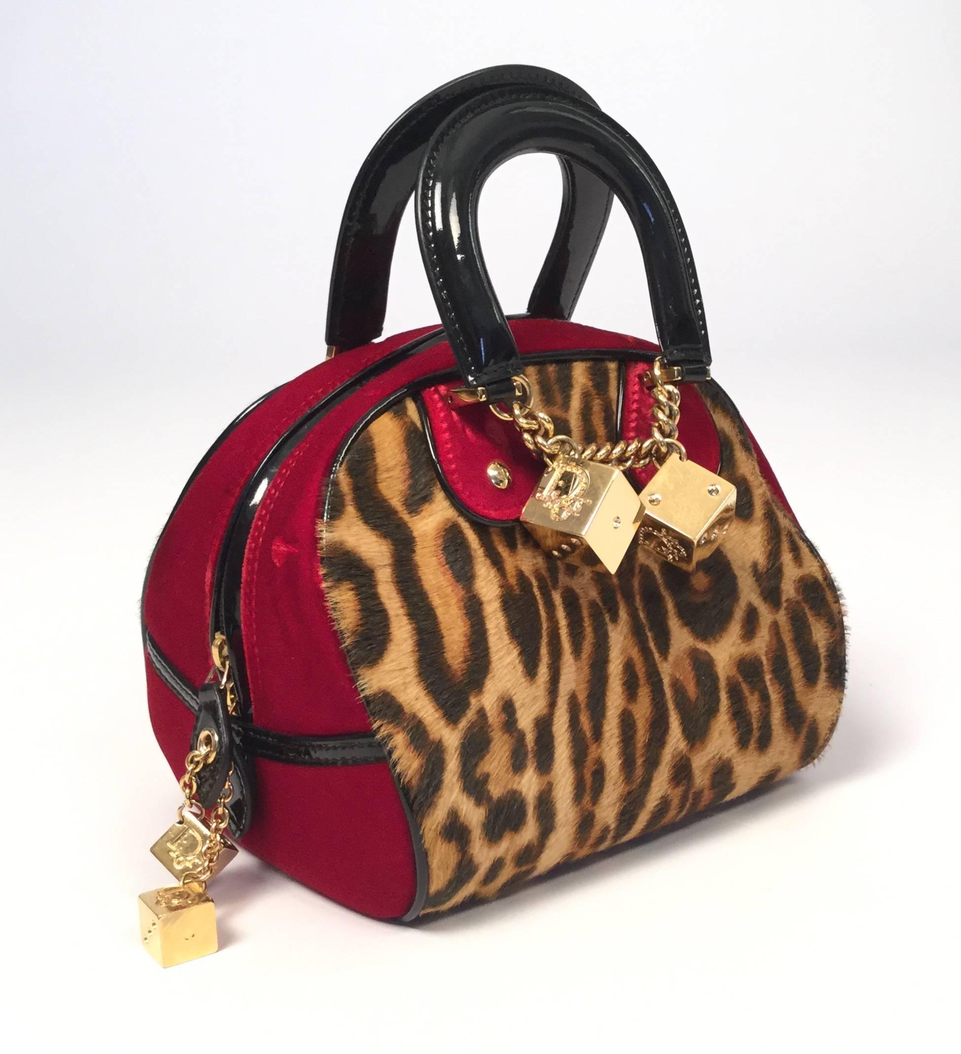 Perfect for fall comes this extremely rare 2004 Christian Dior Fall runway handbag.

This "Gambler" handbag is made of leopard print pony and luxe ruby red velvet with black patent leater trim on the handles and surrounding the body of