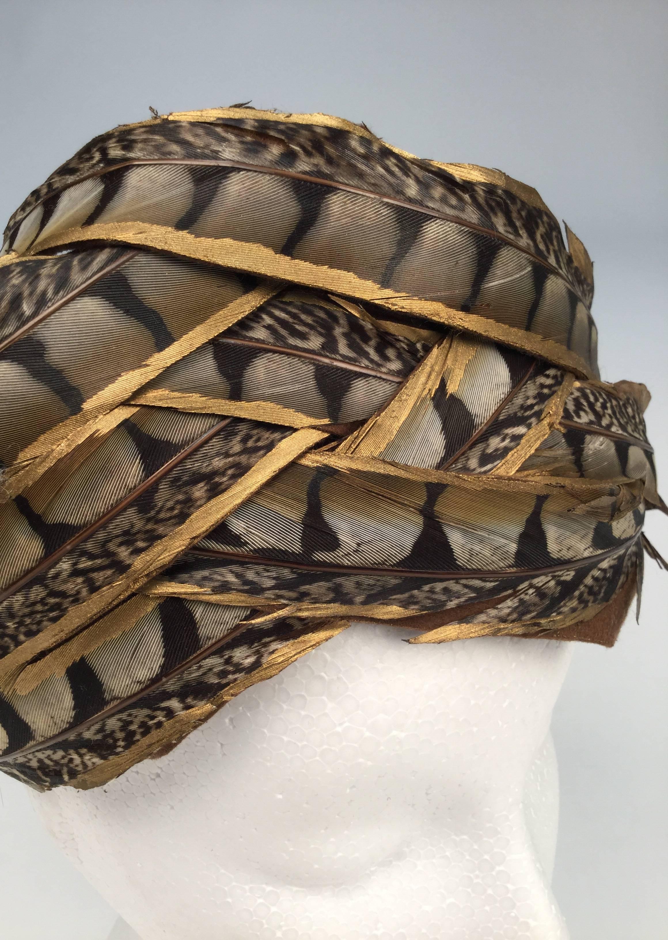 Remarkable 1960's Christian Dior pheasant feather chapeaux. 
Feathers are hand painted with and dipped into gold paint.   Feathers are, woven into and wrapped around, the hat in a turban style.  Feathers beautifully placed atop a brown mesh
