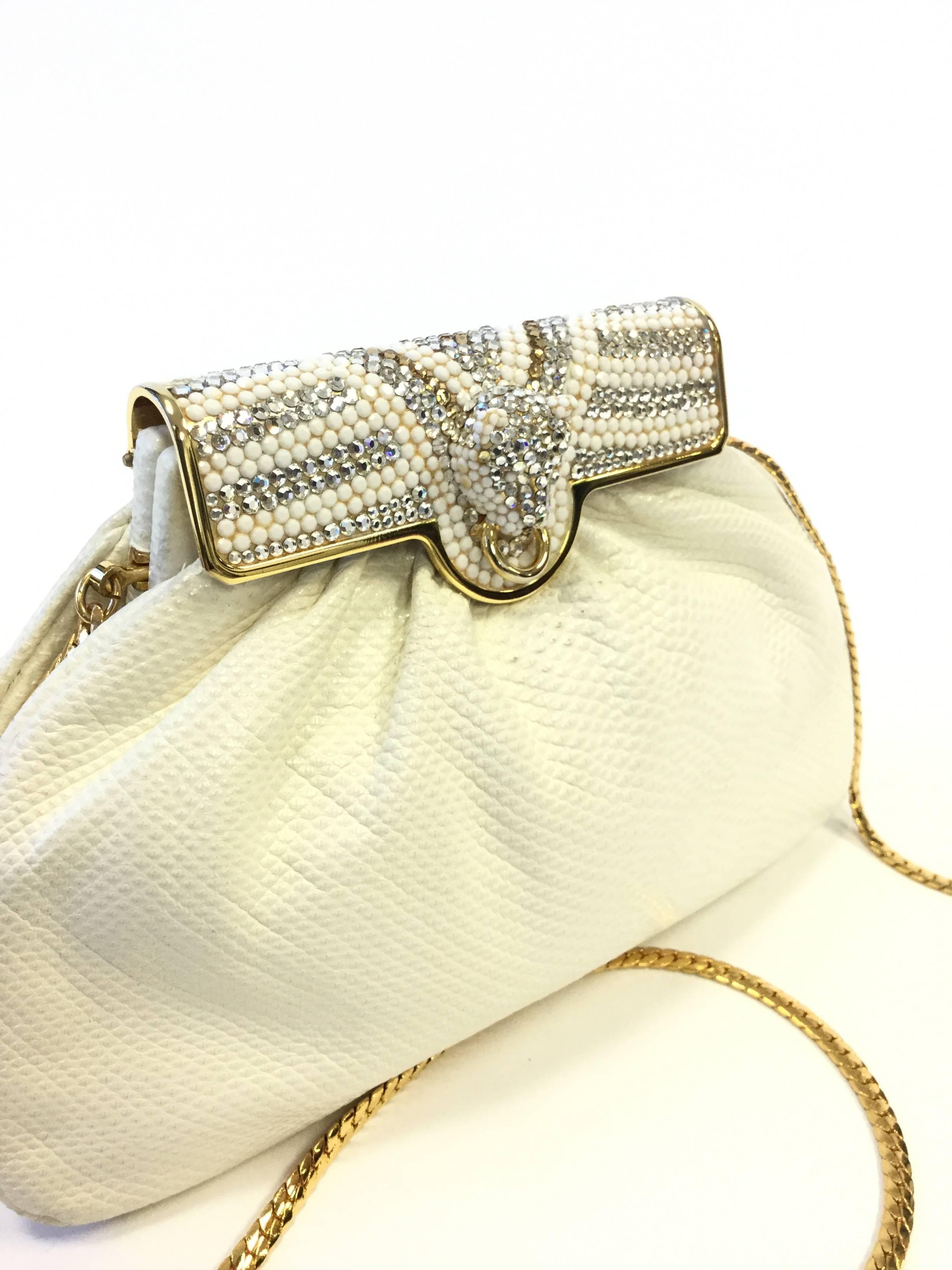 
Stunning and glamorous evening purse by Finesse La Model! This evening purse has a soft, white, plush snakeskin body with an ornate seed bead and rhinestone clasp. The clasp has a puma head design on it; the big cat is encrusted with rhinestones,