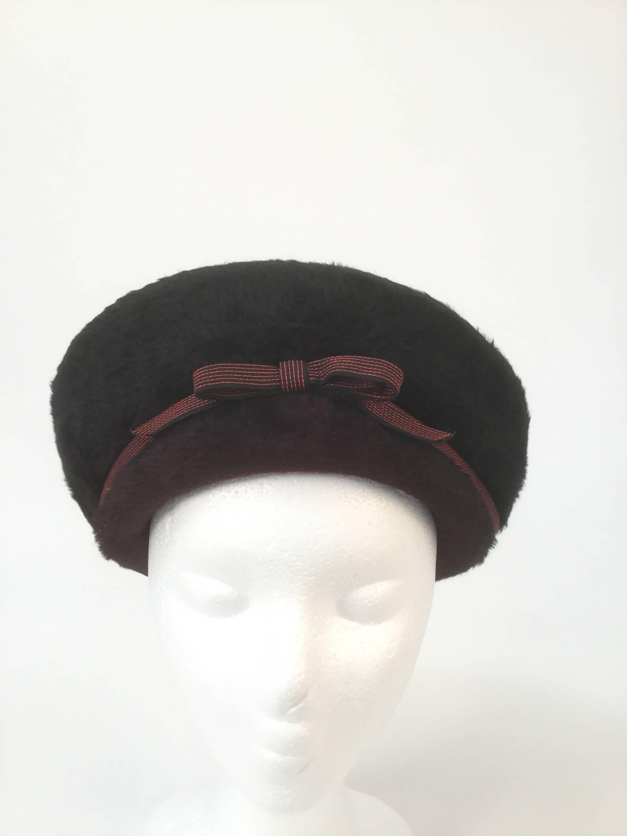 
Striking red and black felt hat by Elsa Schiaparelli! This structured hat has aristocratic eastern influences, resembling a cossack hat, a Manchurian hat, and a Qing dynasty winter court official hat! The hat has a black upturned brim that rises