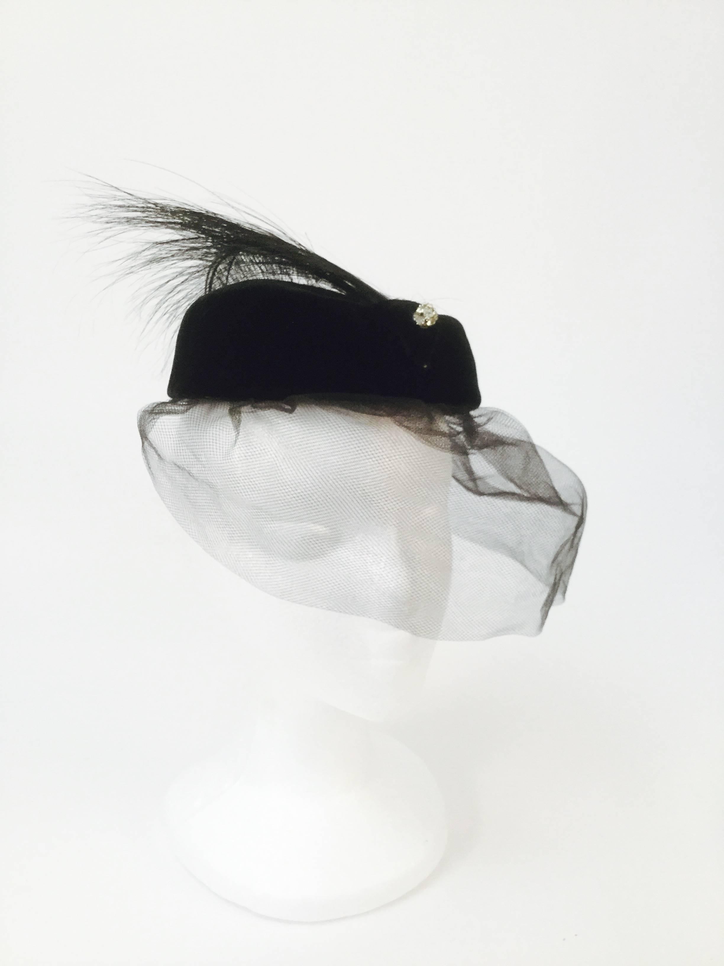 
Elegant Miss Sally Victor pillbox hat! This velvet pillbox hat features a small triangular patch at the front, accented with a delicate rhinestone cluster sphere.  Four burnt ostrich feathers spring from beneath the velvet triangle, resting over